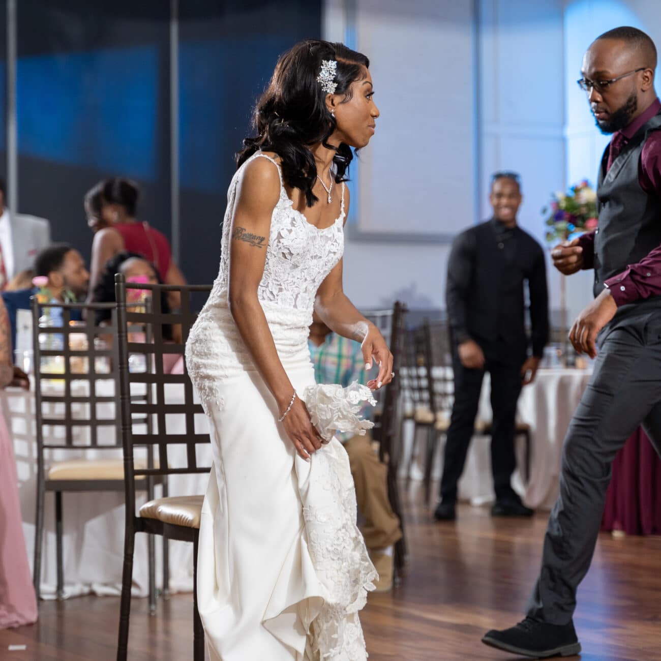 Bride getting ready for the bouquet toss at the wedding, with Dontavious Chesson walking in the background of the image.