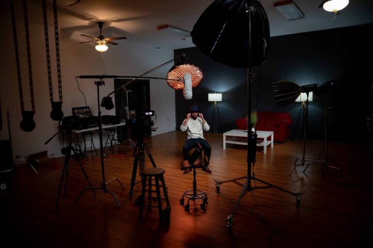 Man sitting in video recording studio with blackmagic equipment as a cinematographer
