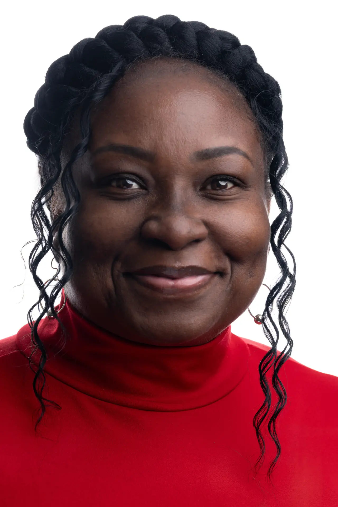 Woman with braids in a red turtleneck smiling, studio headshot