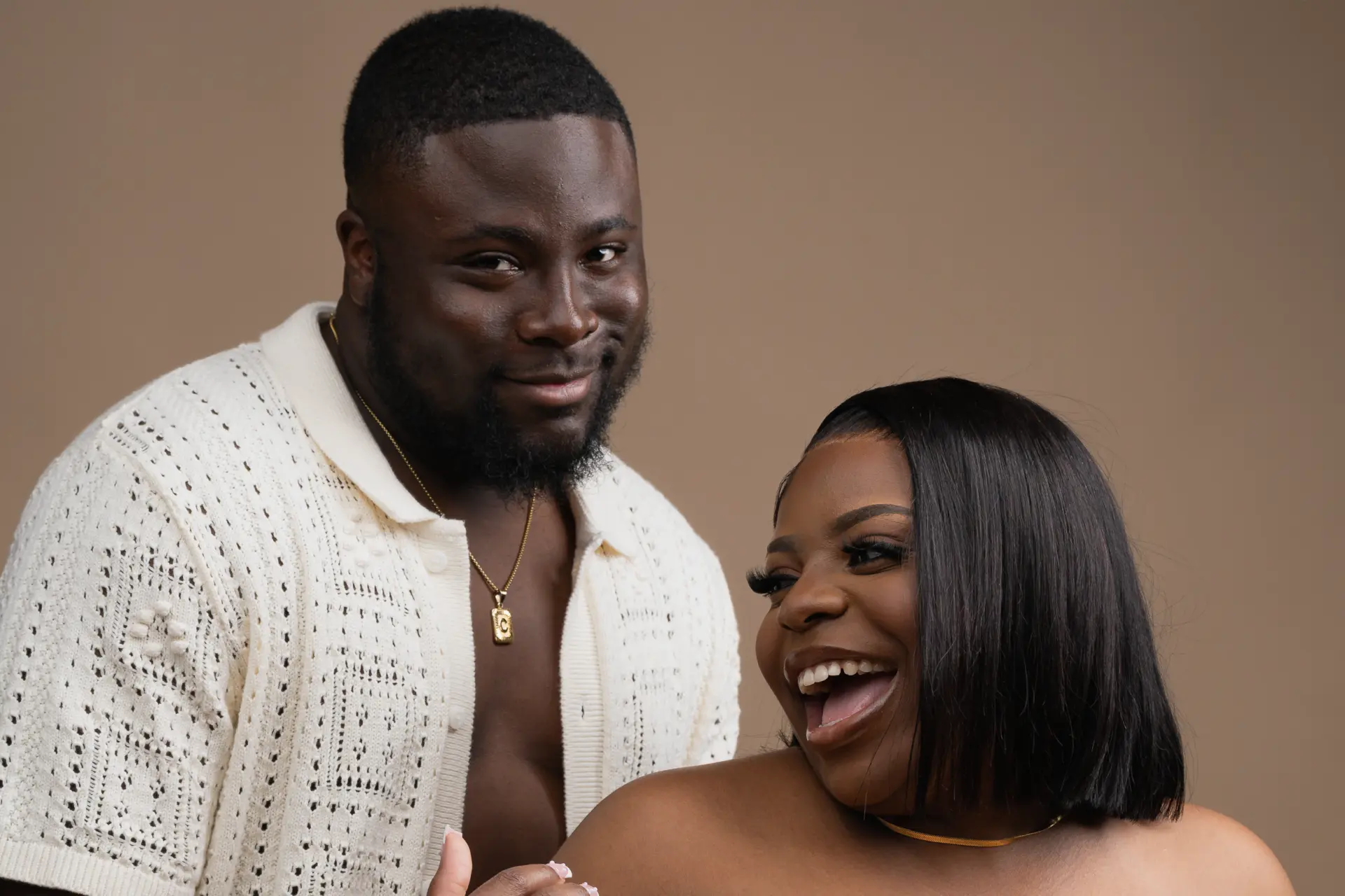 Couple embracing and laughing in a warm studio portrait