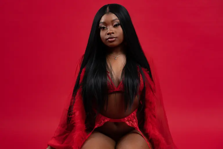 Woman in a red robe against a bold red backdrop
