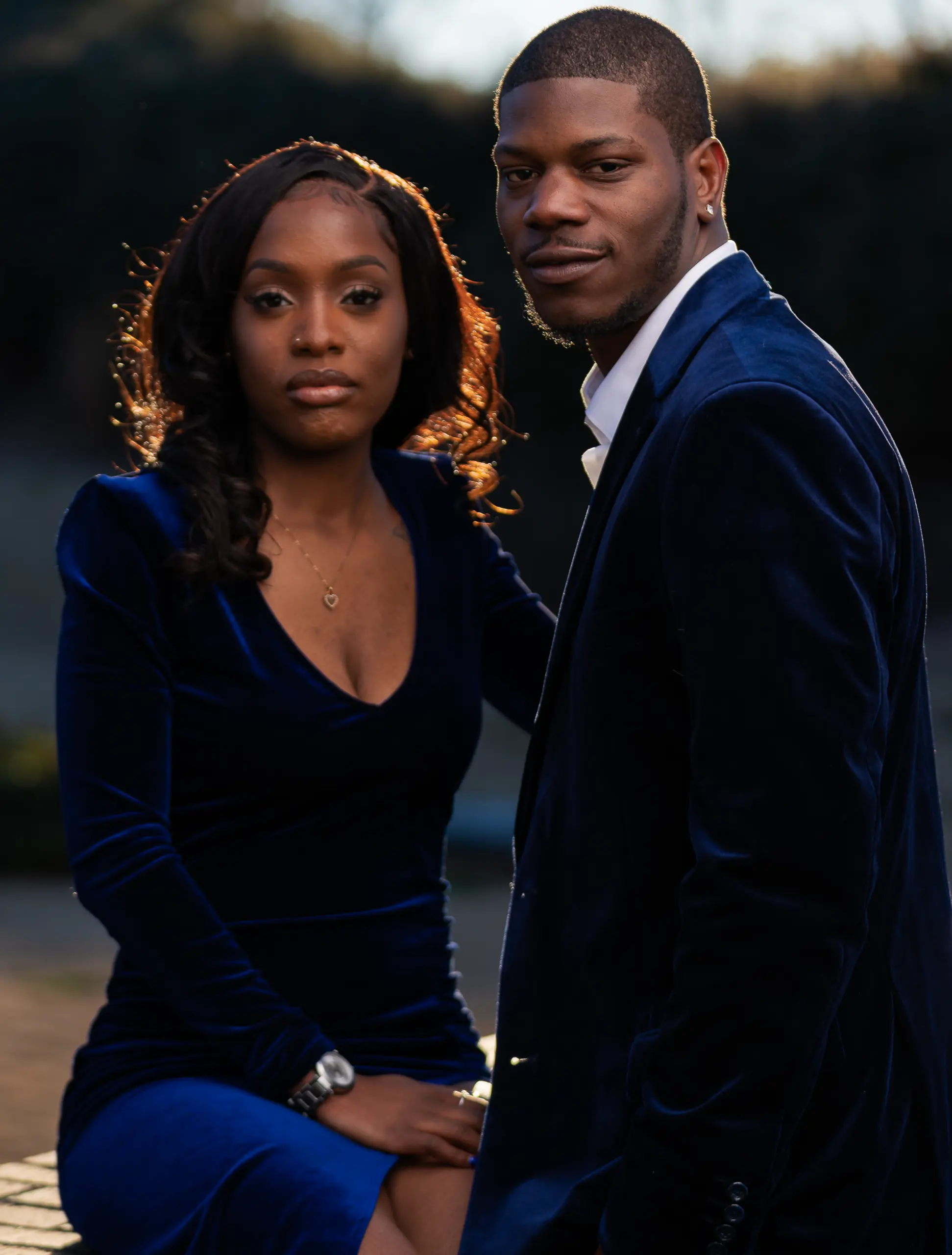 Couple in blue and navy stands side by side outdoors