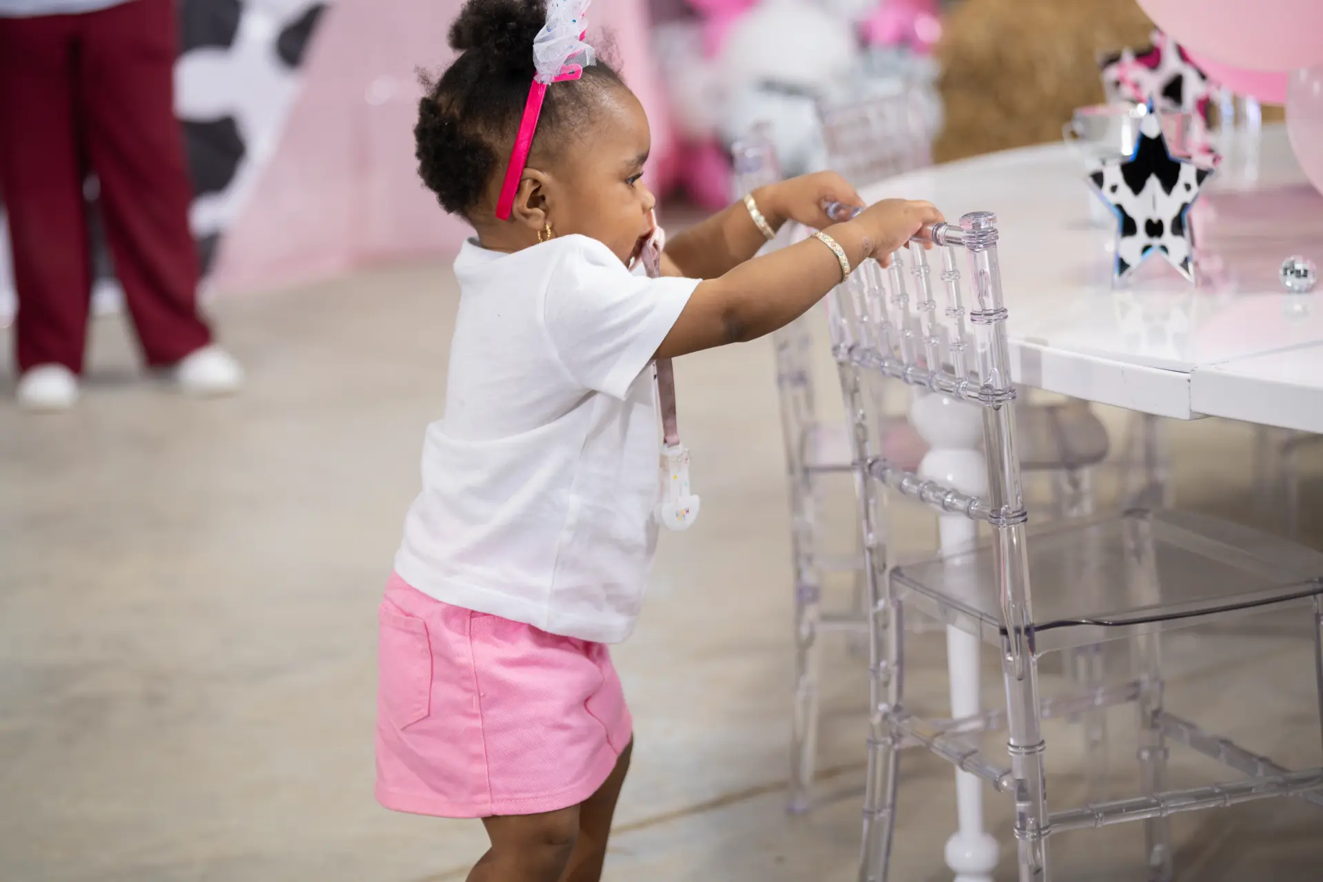Toddler in pink exploring the party decorations