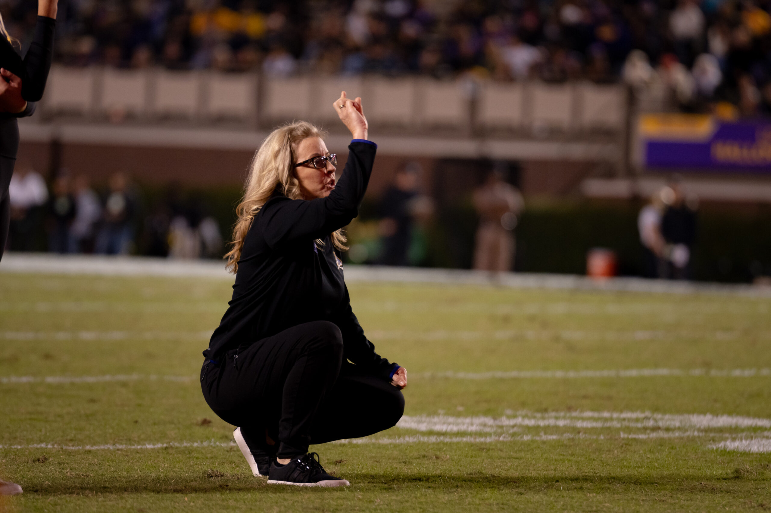 My First ECU College Football Photography Assignment 75 Woman crouching on the sideline photographing the game
