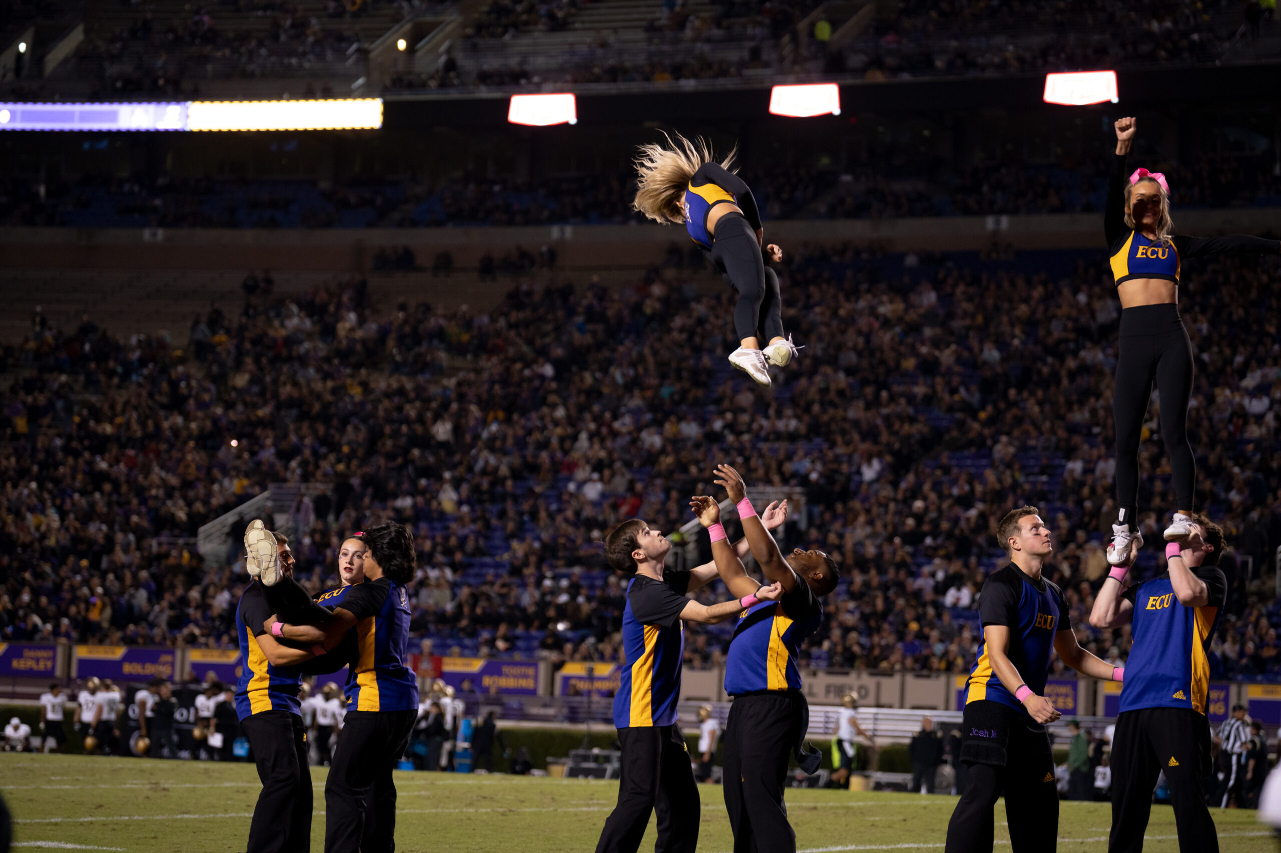 My First ECU College Football Photography Assignment 158 ECU cheerleader tossed into the air on the sideline