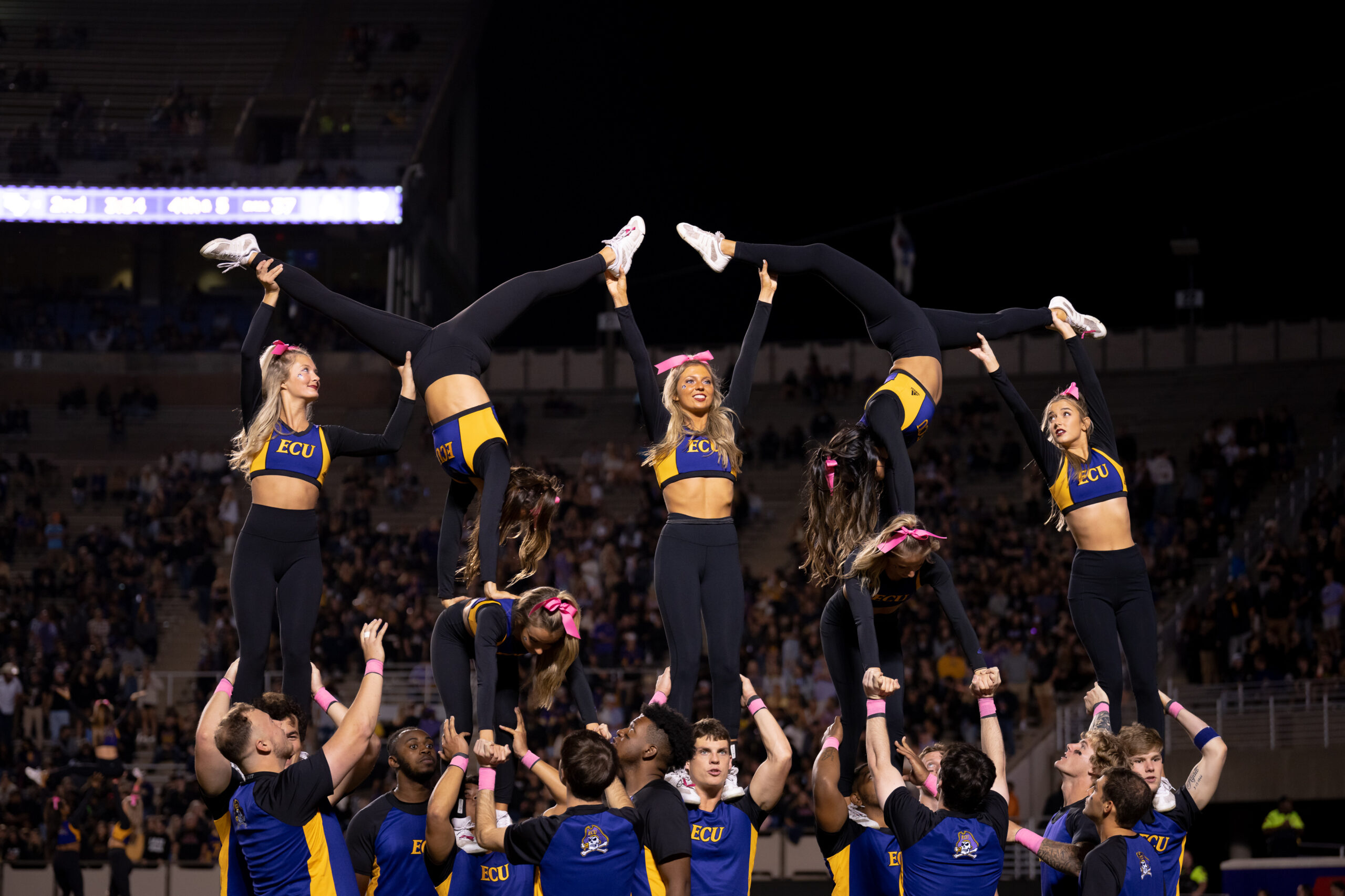 My First ECU College Football Photography Assignment 1 ECU cheerleaders building a pyramid on the sideline at night