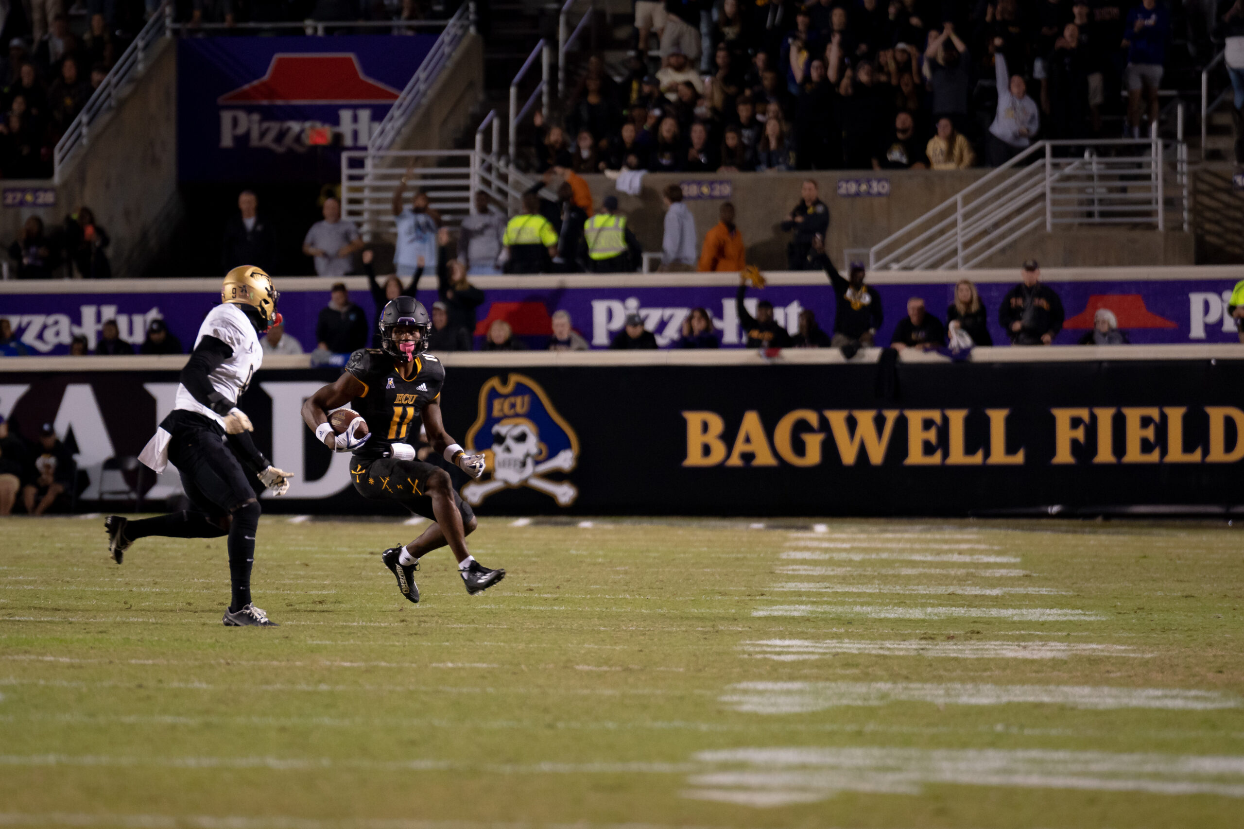My First ECU College Football Photography Assignment 25 Player breaking downfield in front of the Bagwell Field sign