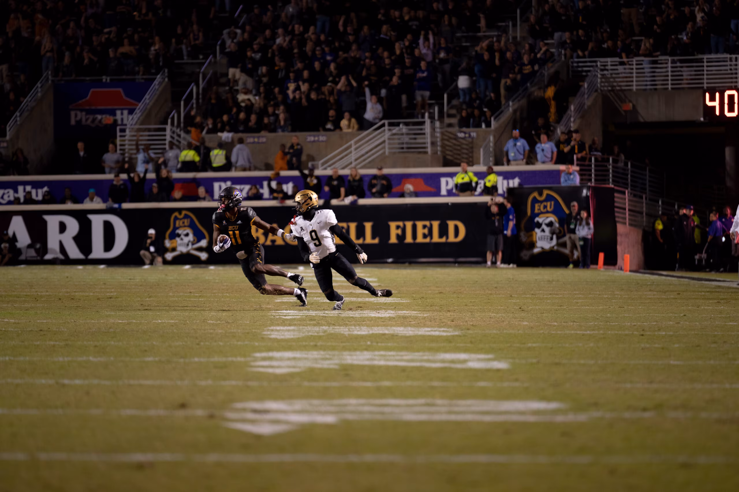 My First ECU College Football Photography Assignment 279 Players running toward the end zone in front of the Bagwell Field sign