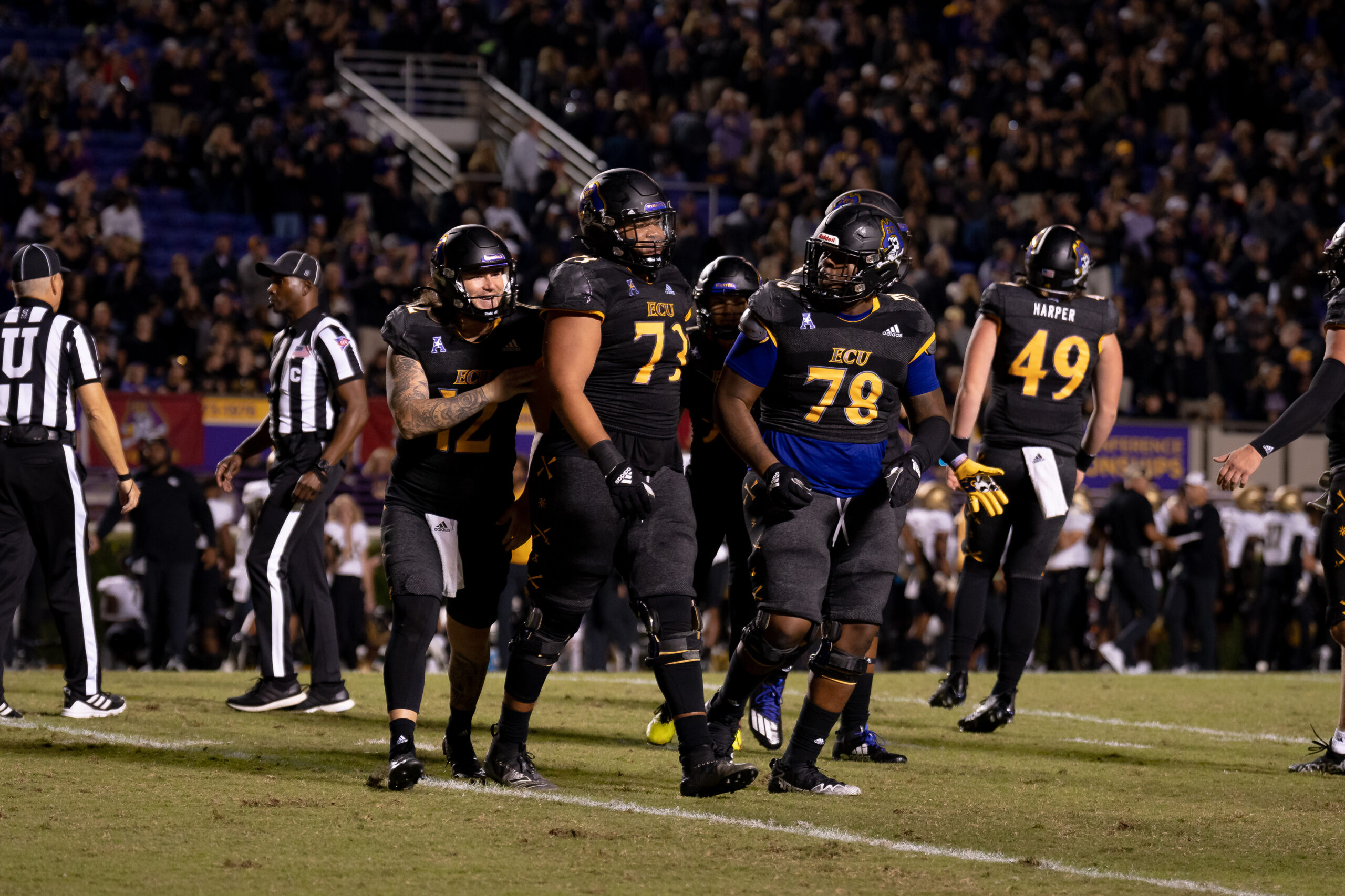 My First ECU College Football Photography Assignment 8 ECU players huddled on the sideline under the lights