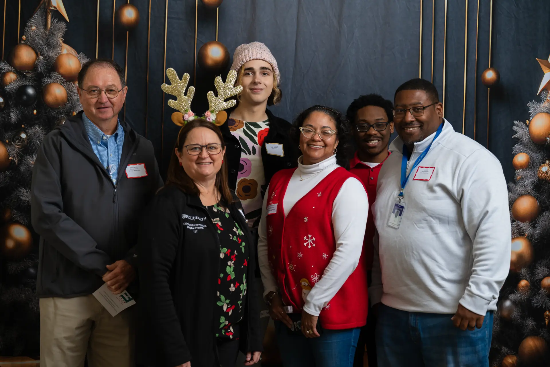 ECU Health coworkers posing in front of decorated Christmas trees
