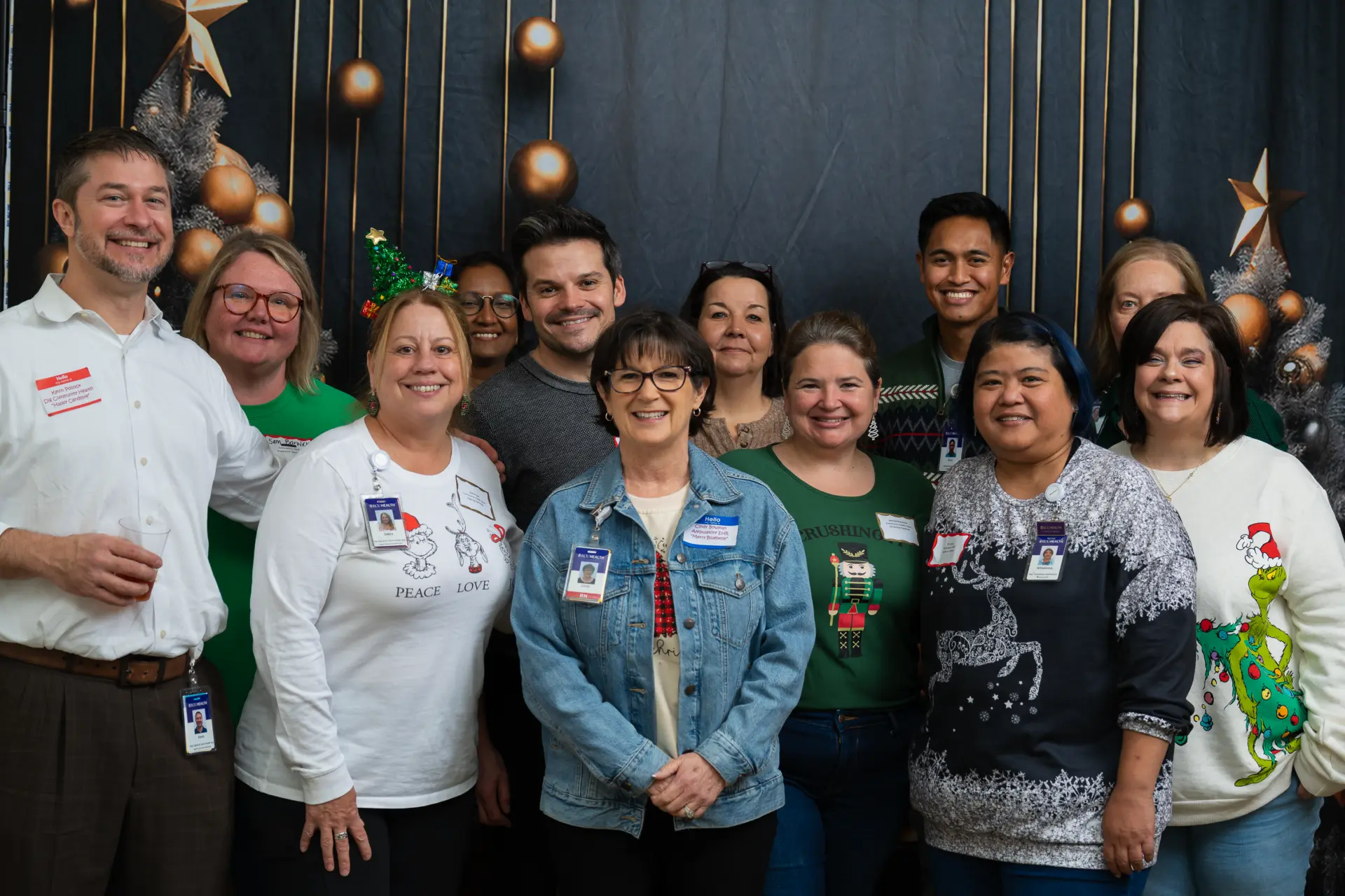 ECU Health team group photo in front of the holiday backdrop
