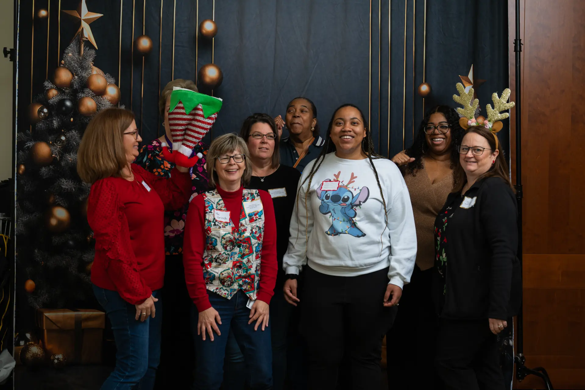 Coworkers in red and white posing at the holiday photo backdrop