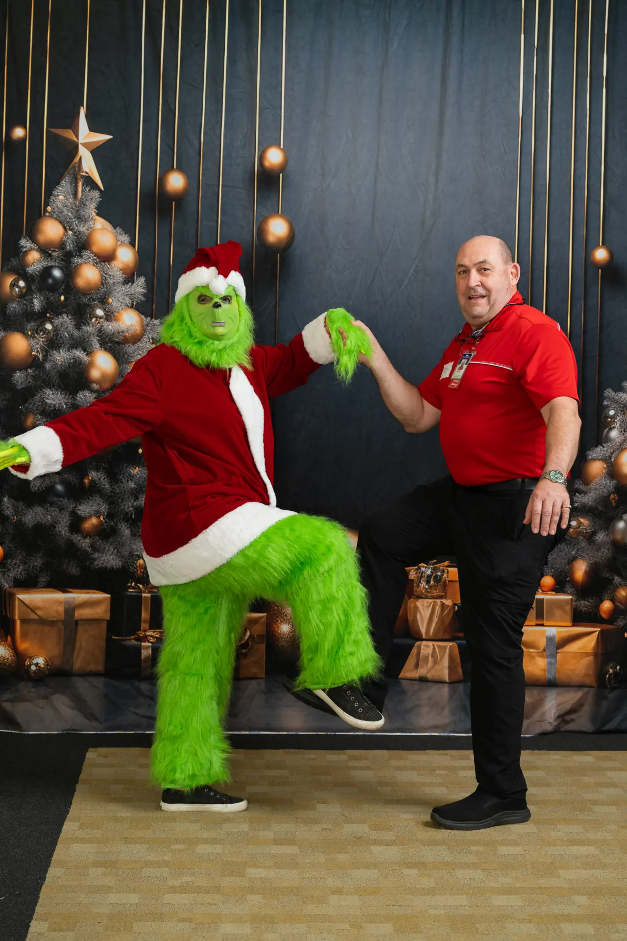 Grinch character and a guest dancing at the holiday photo booth
