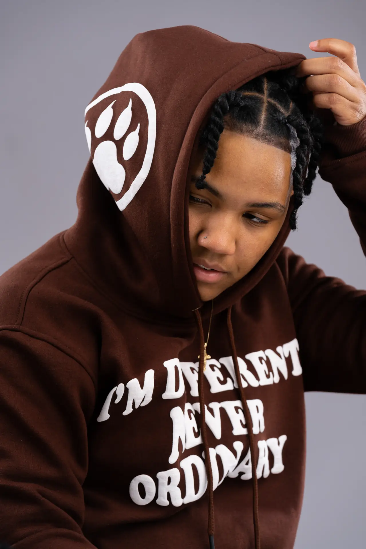 Young man pulling up the hood of a branded brown sweatshirt