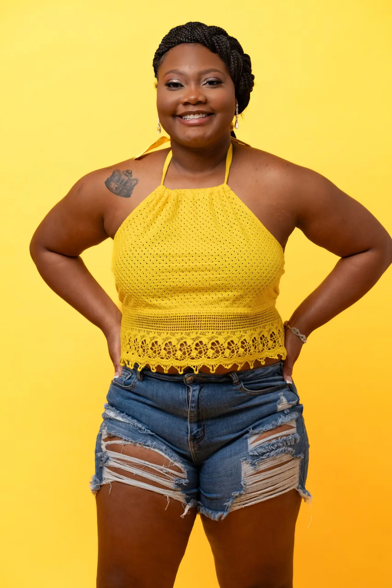 Woman in a yellow halter top against a bright yellow birthday backdrop