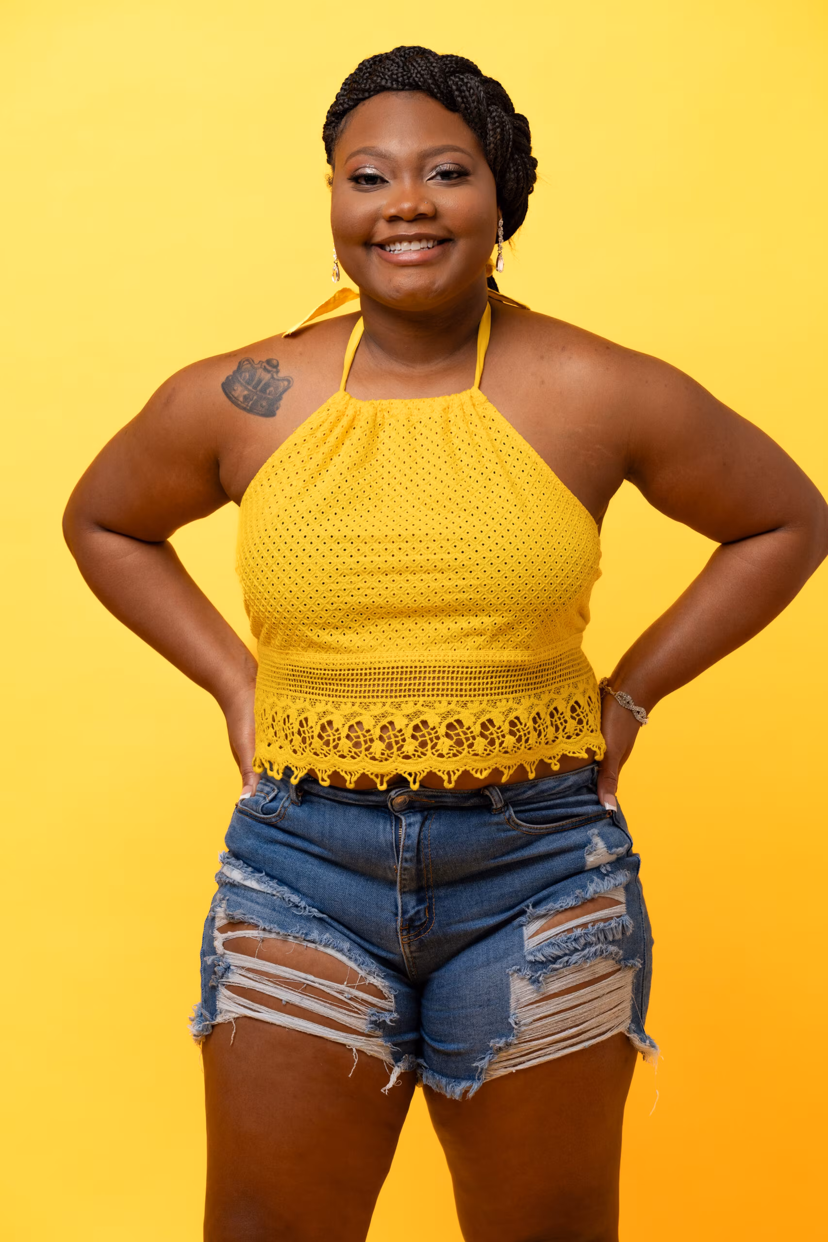 Woman in a yellow halter top against a bright yellow birthday backdrop