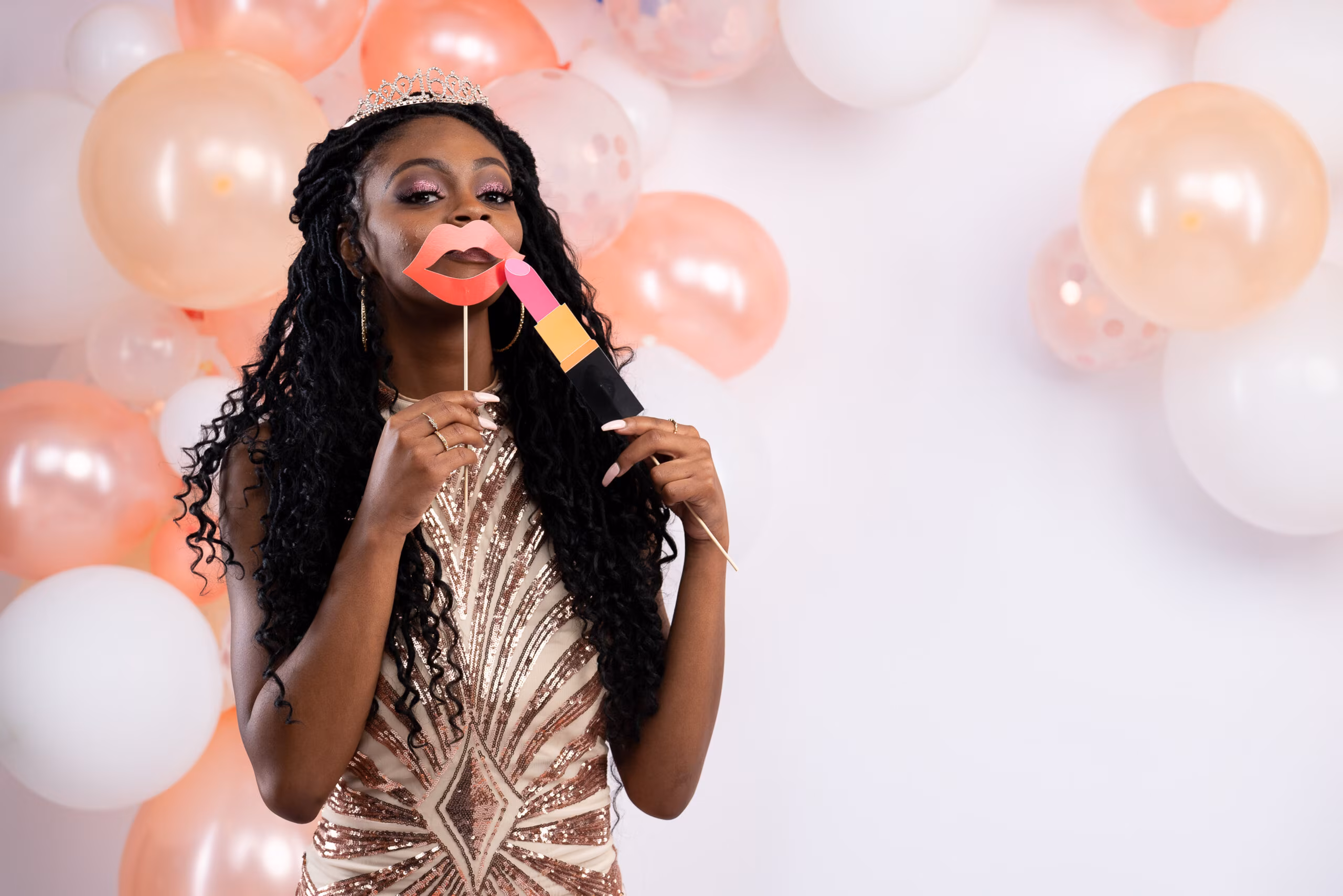 Woman in a sequin dress with lips prop before peach balloons