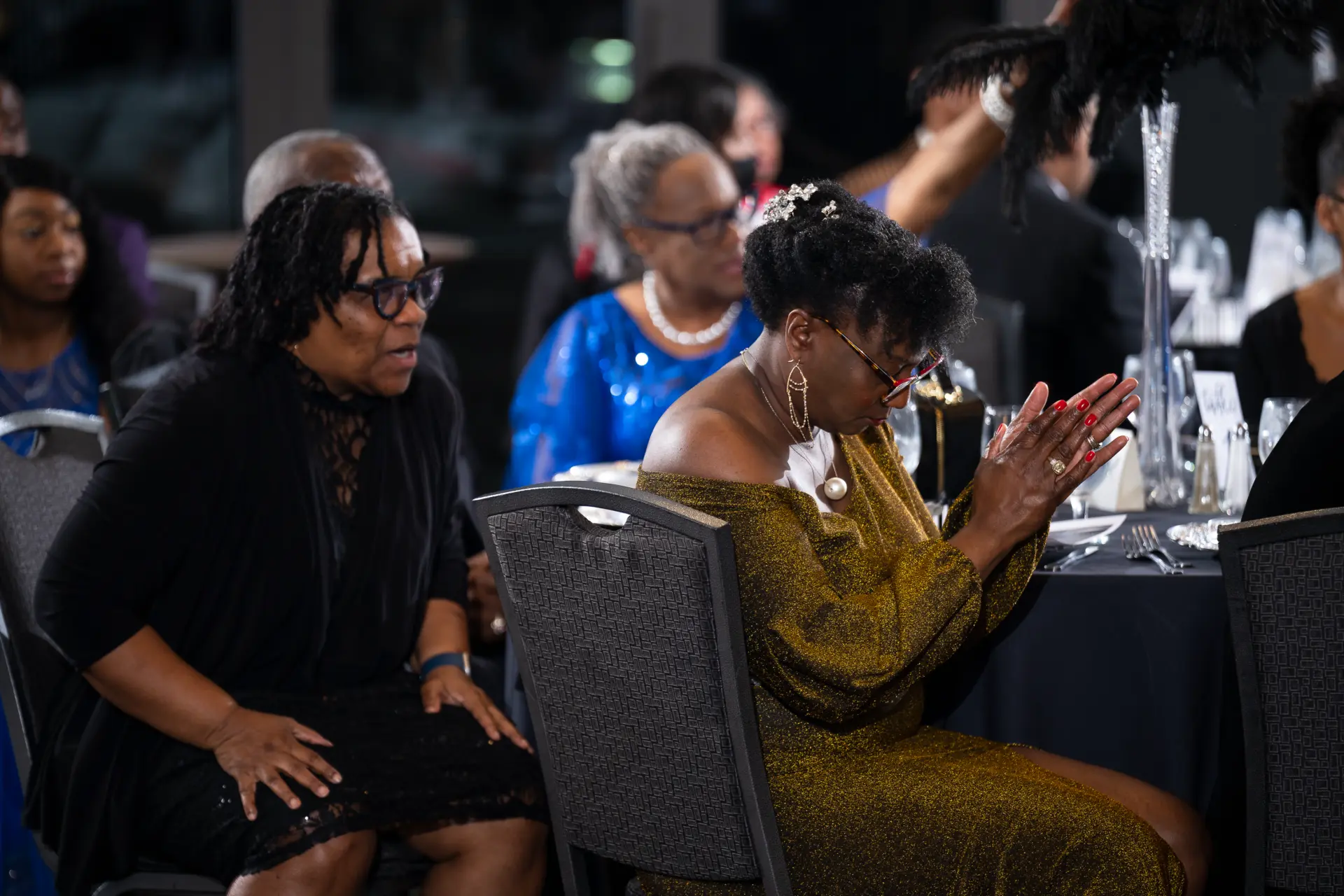 Guests seated at round tables during an evening program