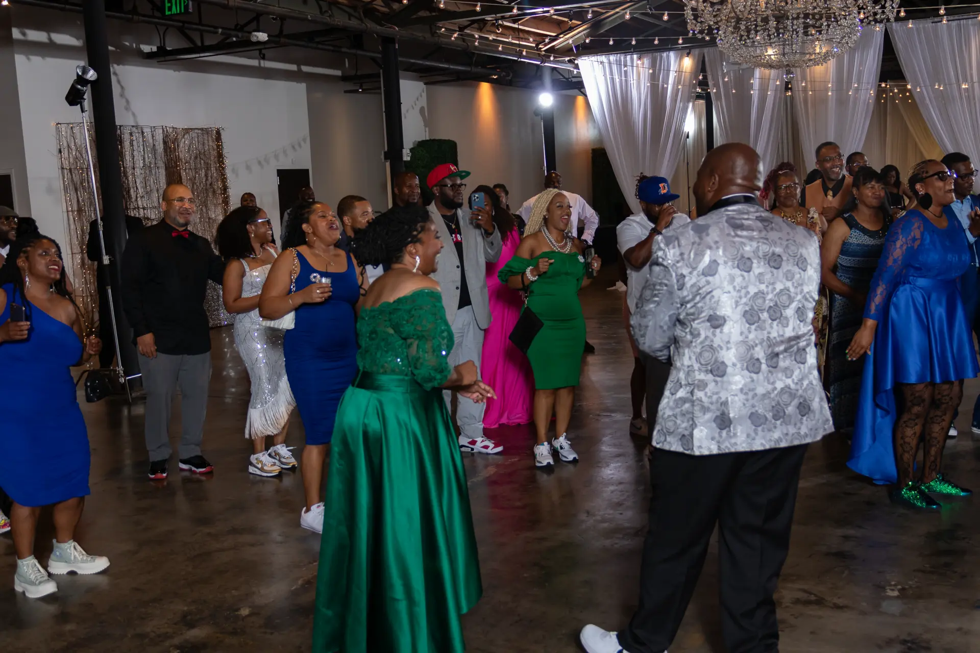 Guests in bright outfits dancing across the event hall