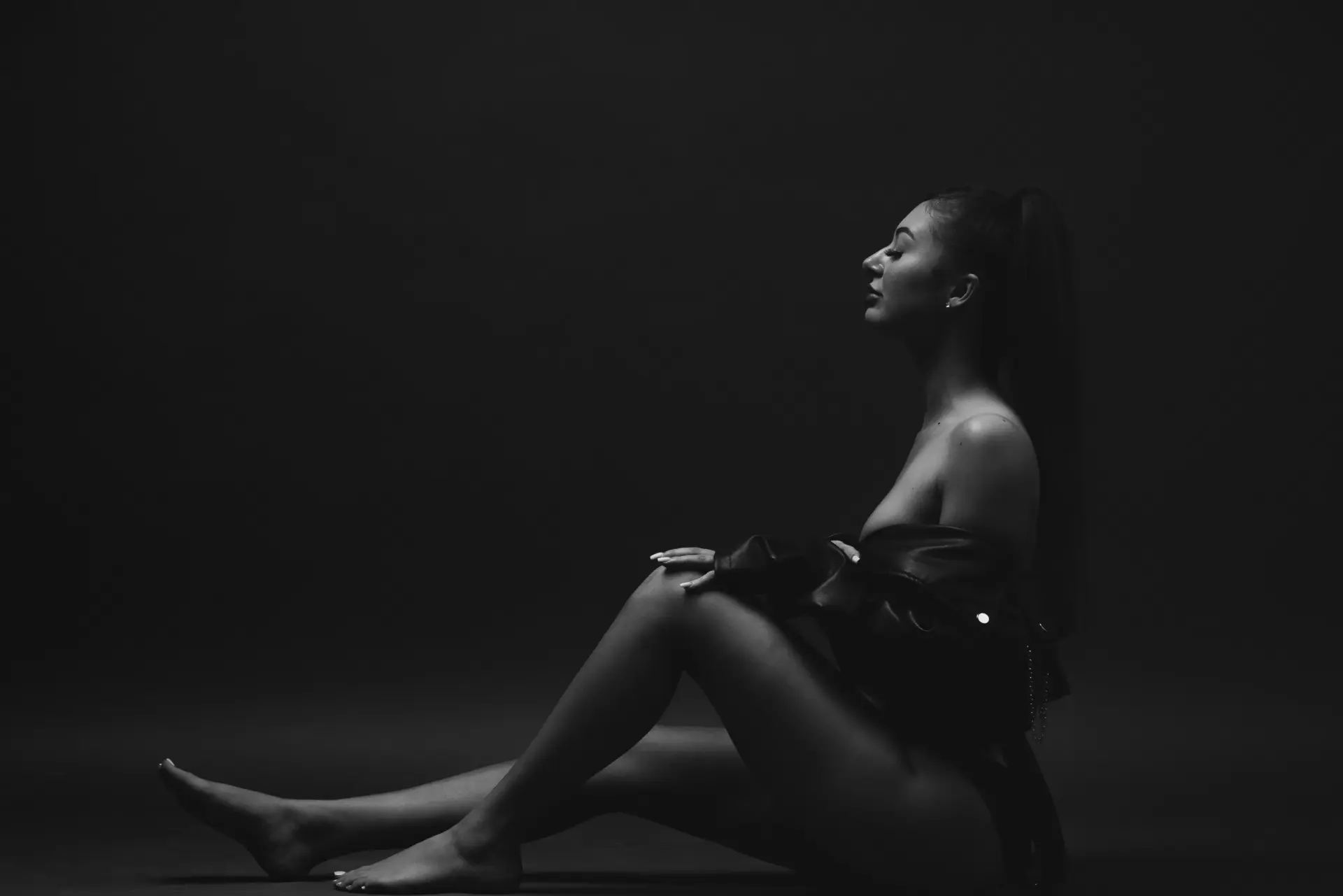 Woman seated in silhouette with dramatic rim light