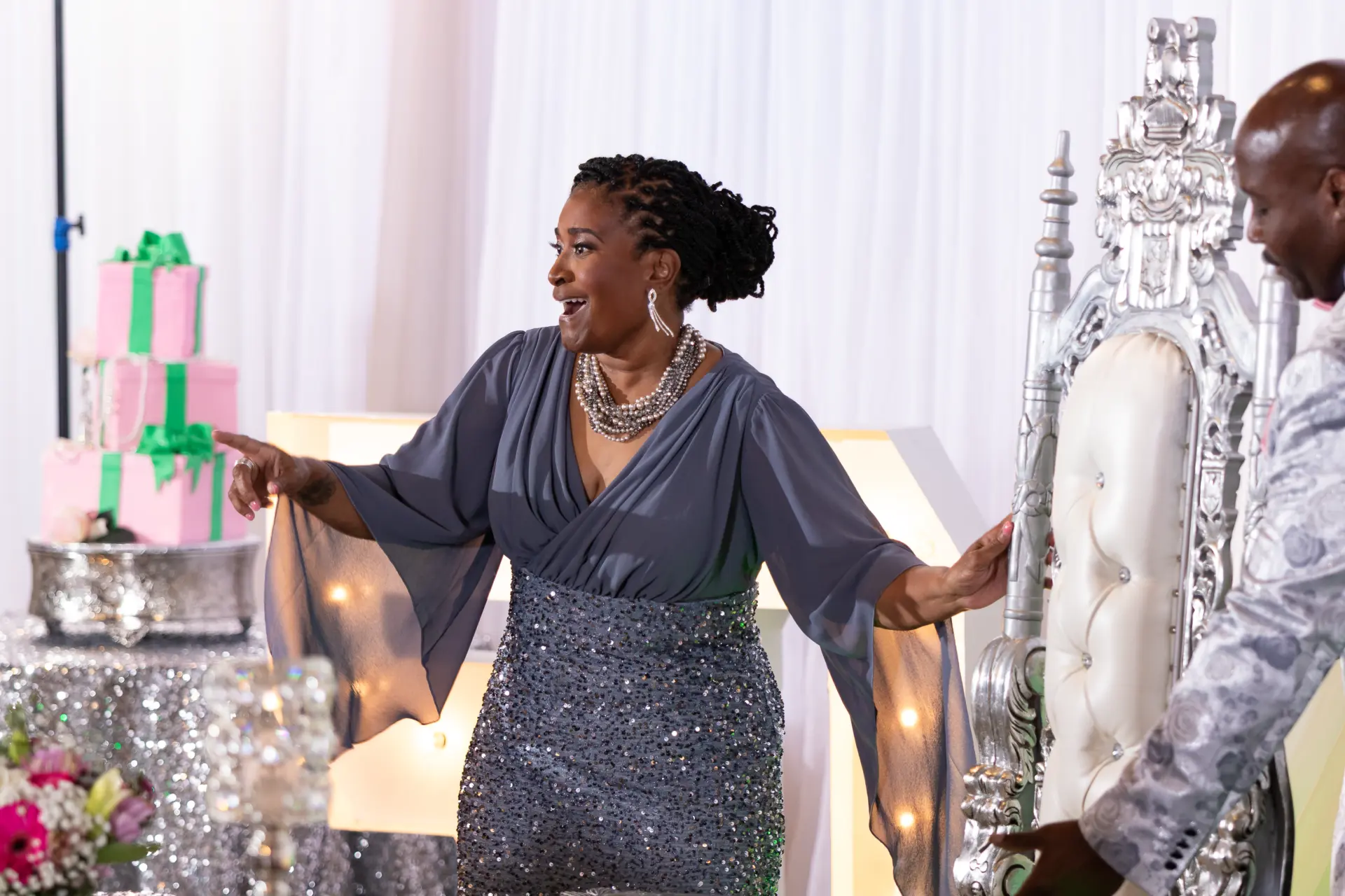 Woman in a sequined dress dancing beside the dessert table