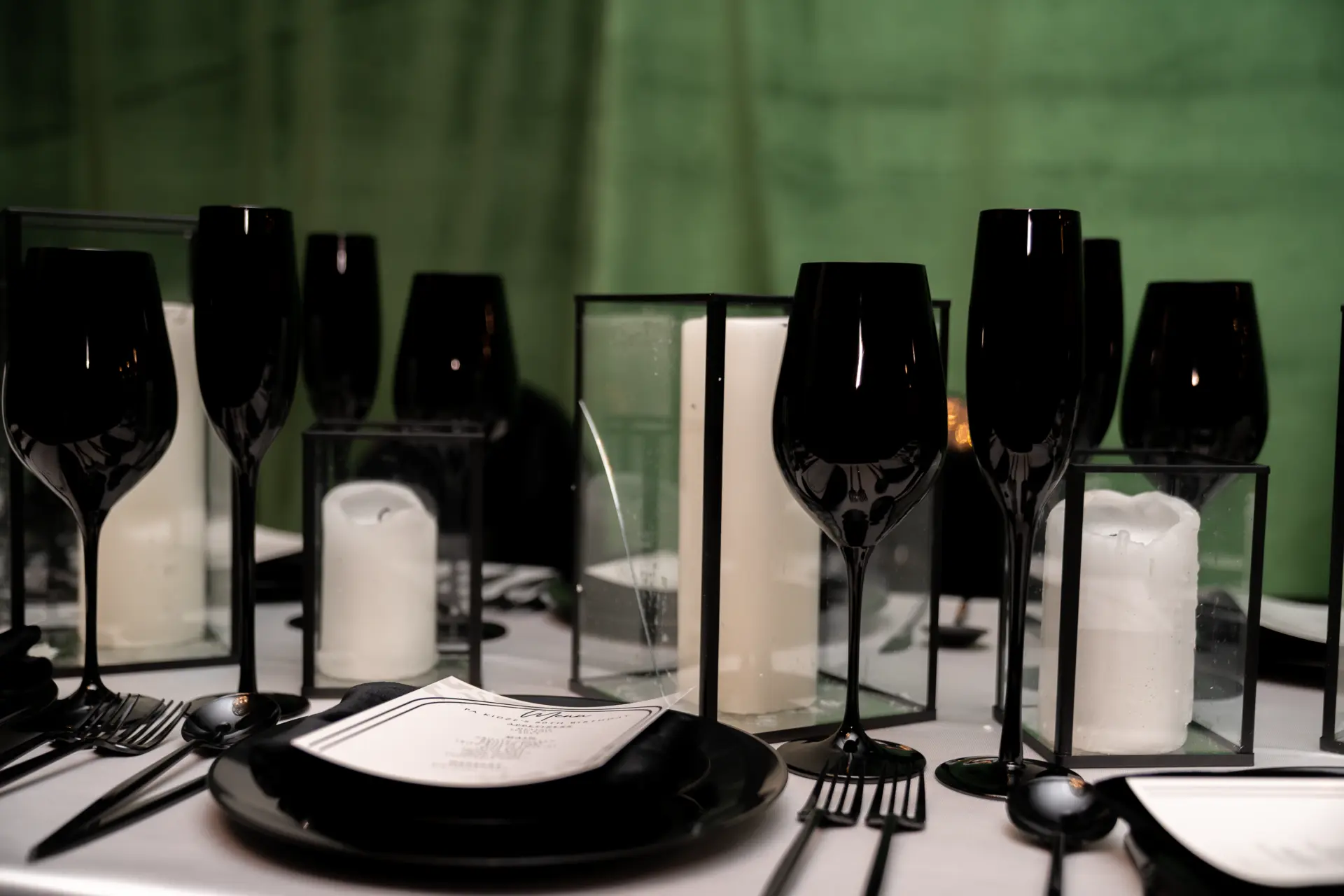 Black glassware and place settings on a styled event table