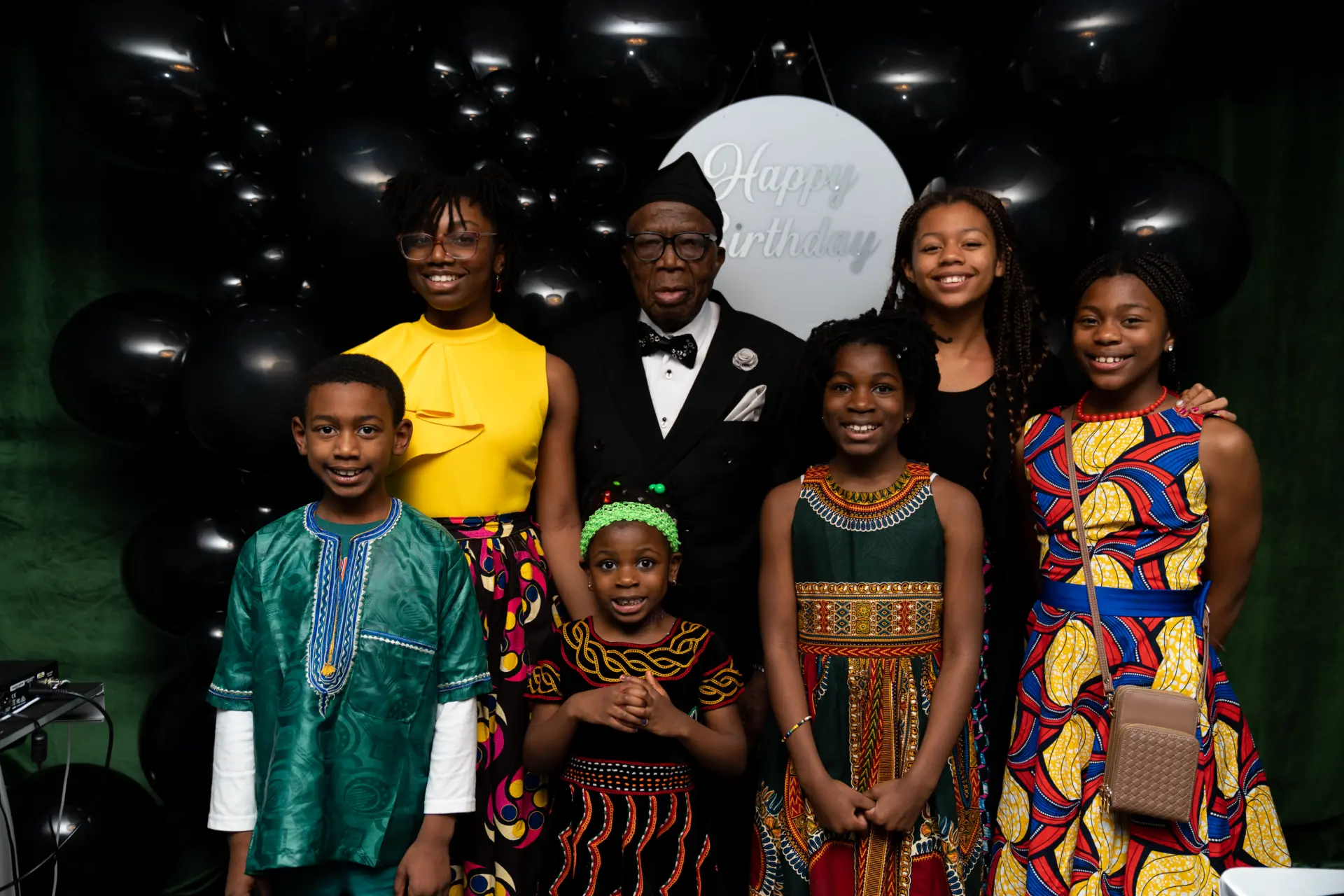 Family in African print attire posing in front of a glowing moon backdrop