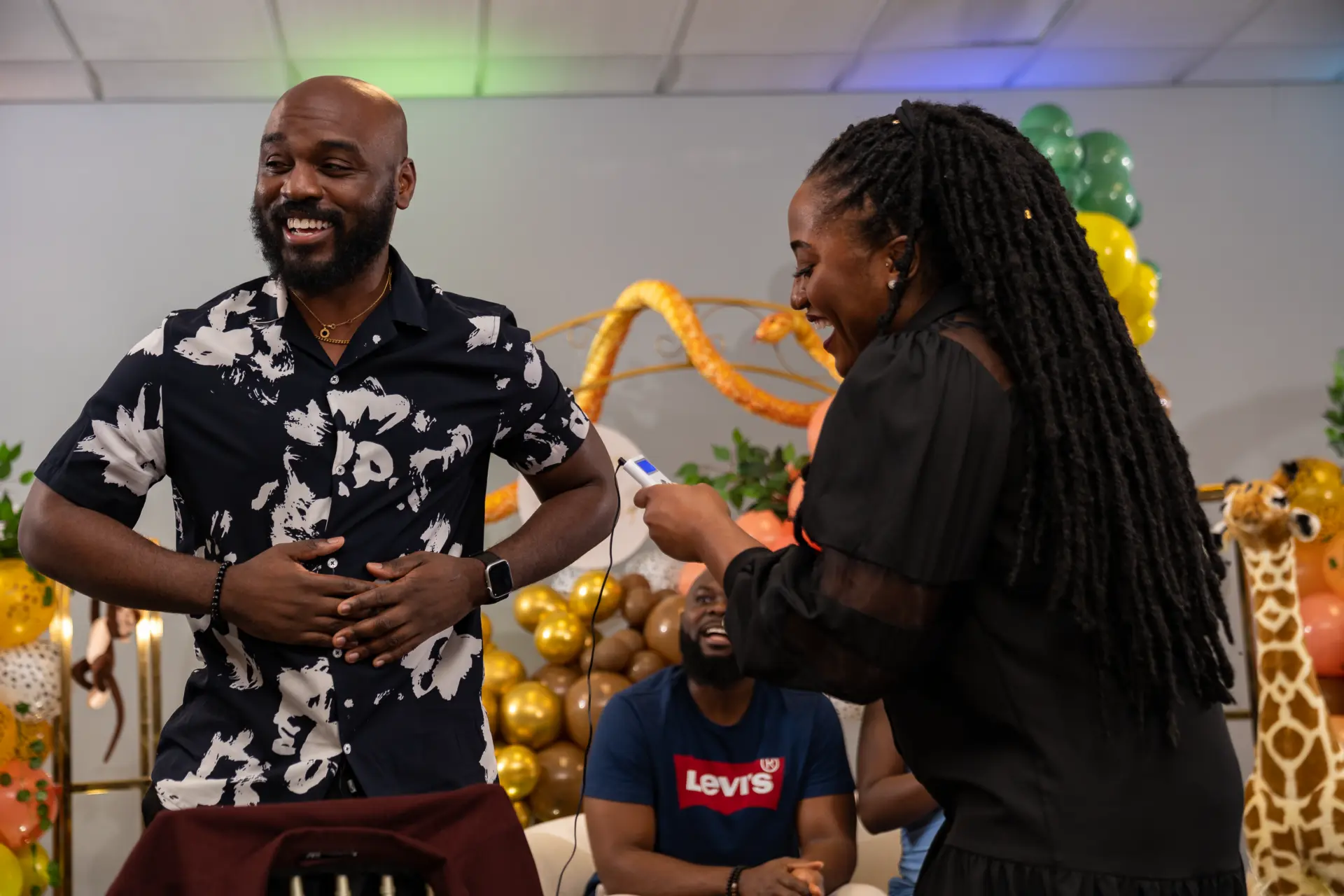 Man in a patterned shirt grooving with a woman at the party