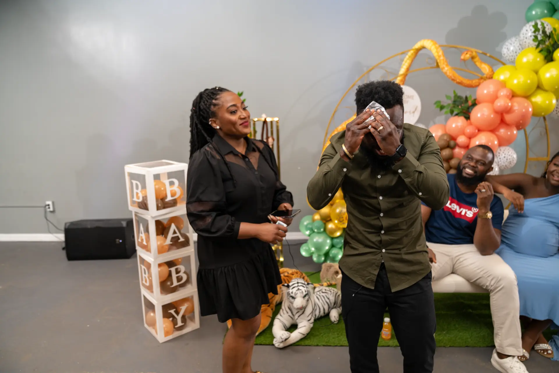 Guests laughing beside floral and balloon decor
