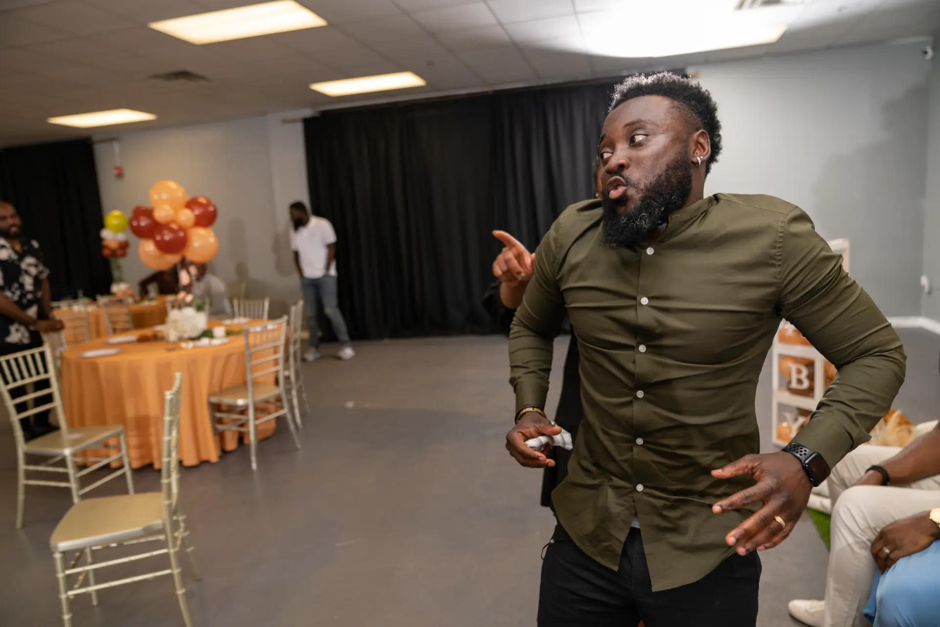 Man in an olive shirt dancing at a celebration