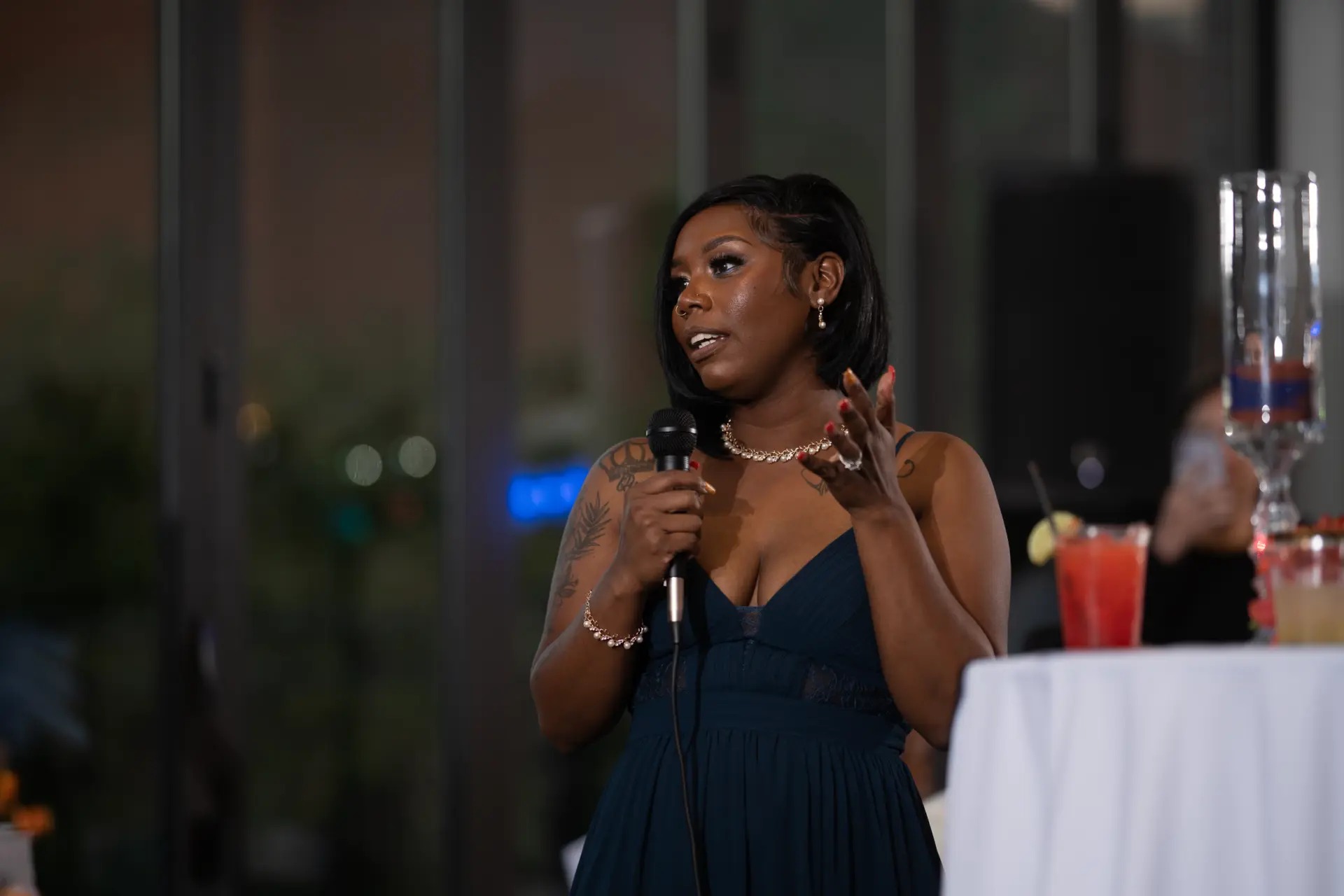 Guest in a blue dress gives a toast at the wedding reception