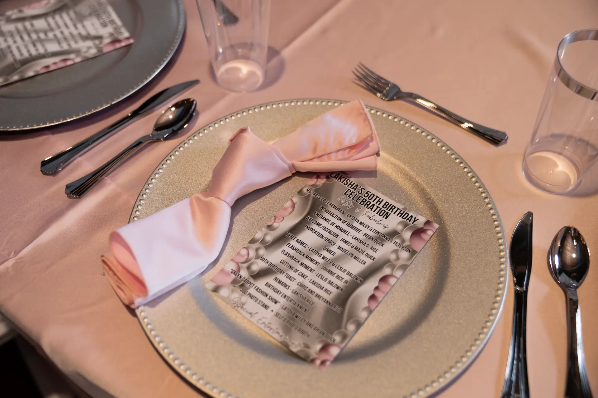 Elegant place setting with a pink napkin and gold charger