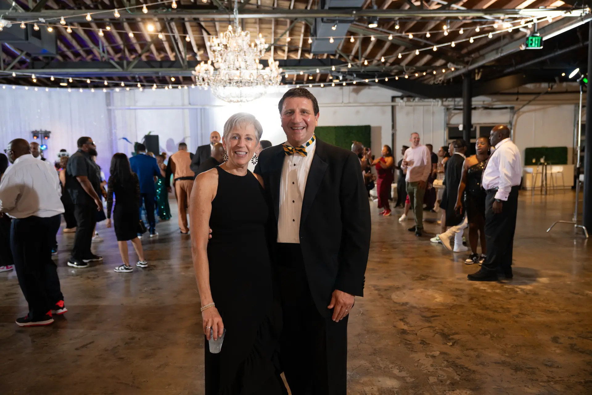 Couple posing on the dance floor under string lights