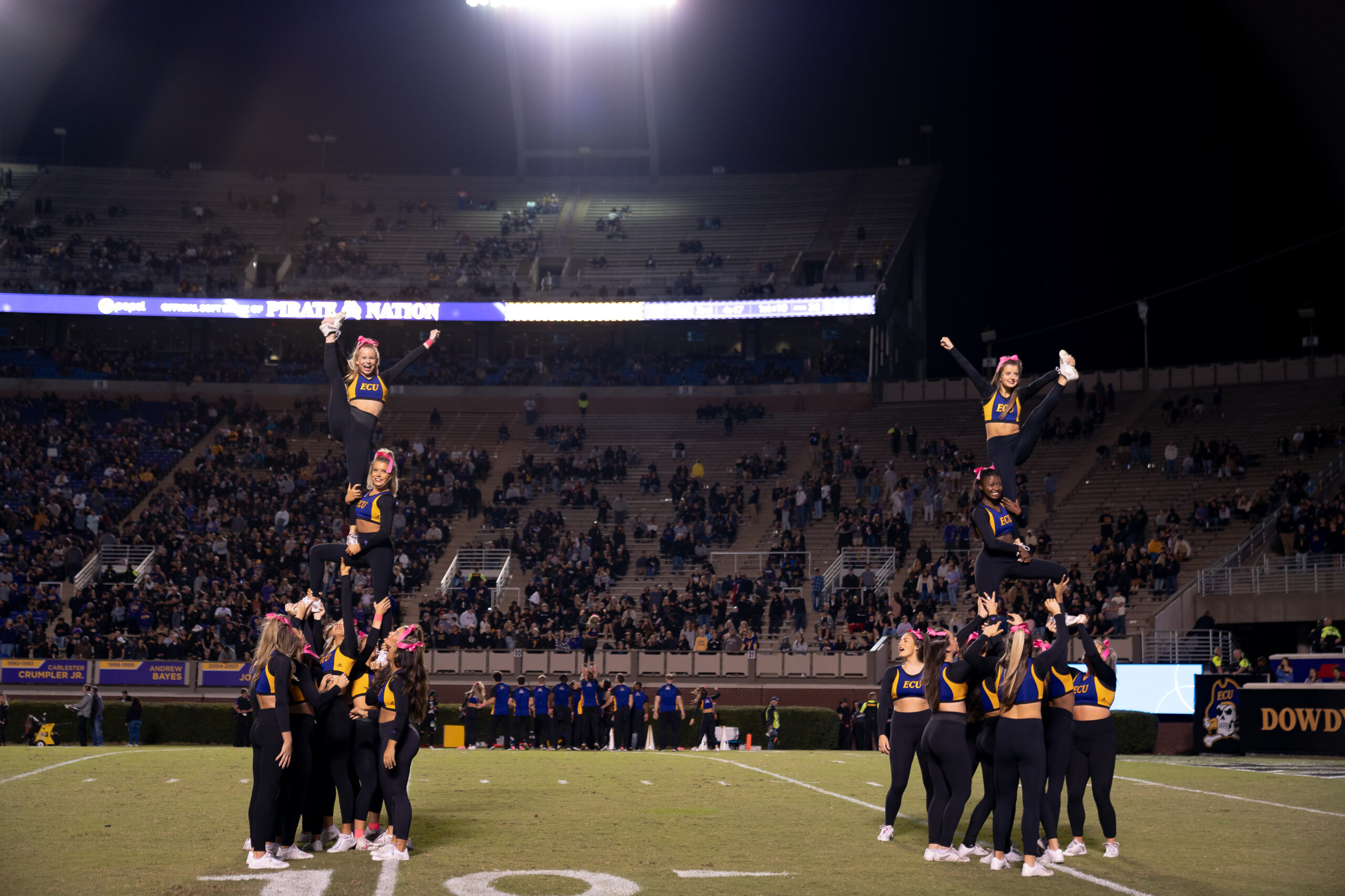 My First ECU College Football Photography Assignment 69 ECU cheerleaders performing a stunt in front of the crowd
