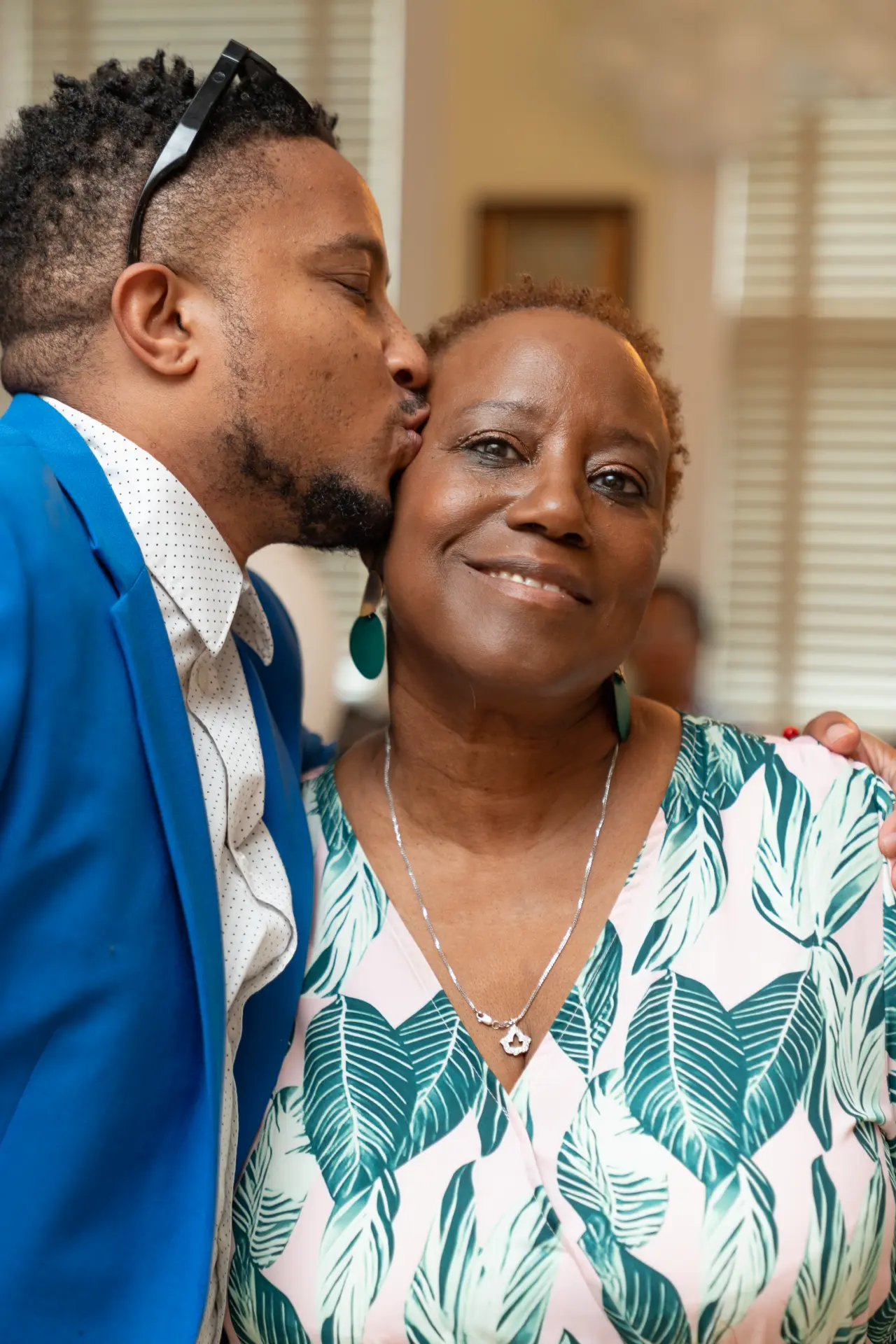 Man in a blue blazer hugging a smiling woman at the party