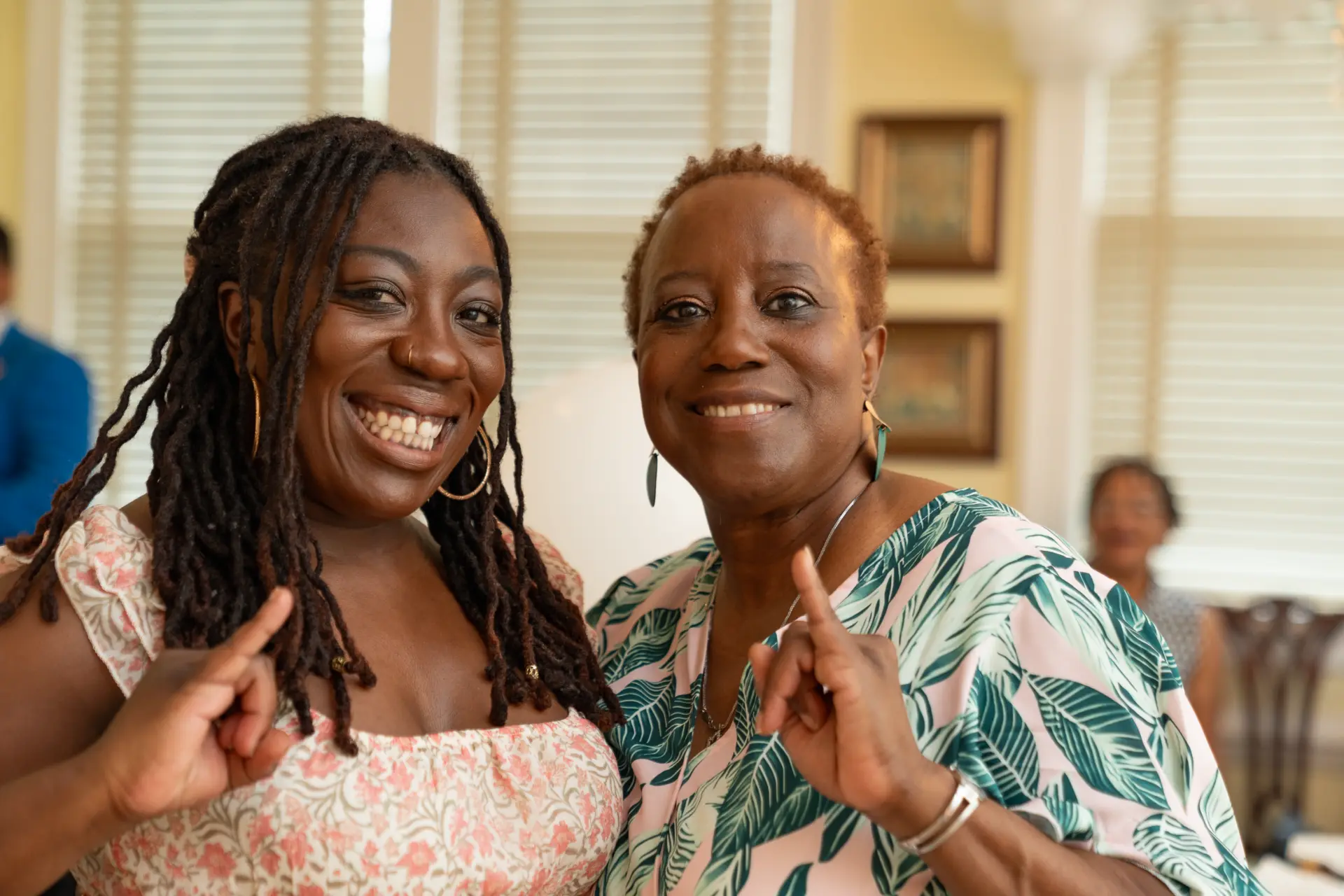 Two women smiling and posing at a family celebration