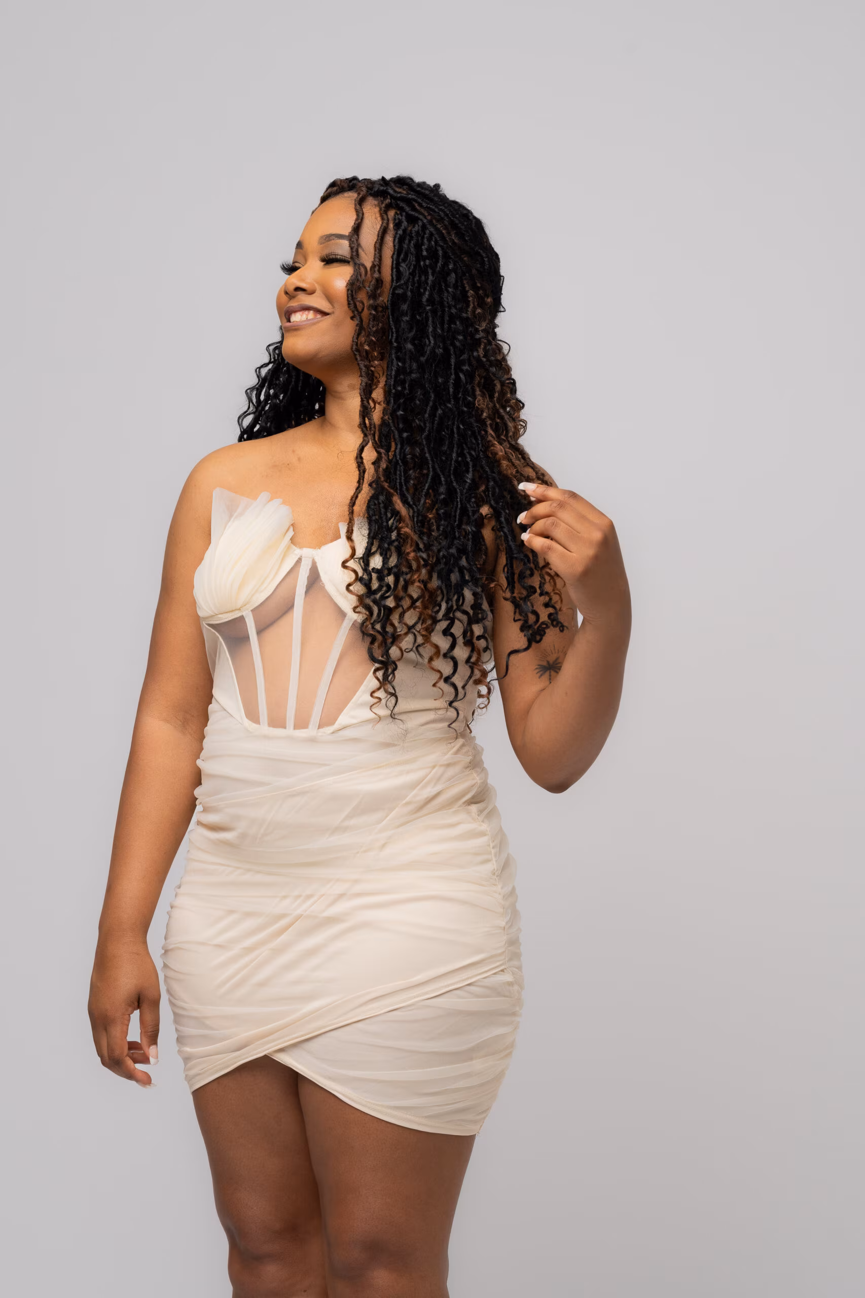 Woman in a white corset dress, birthday portrait on gray