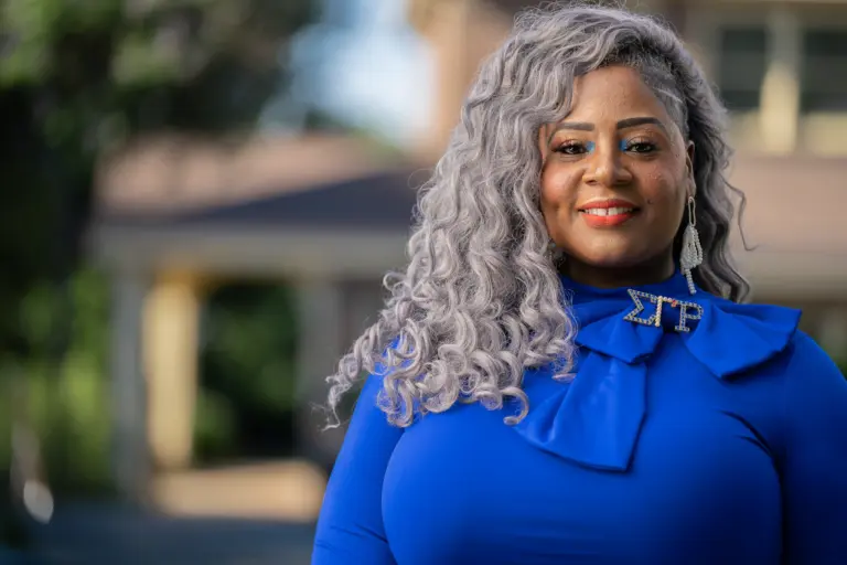 Questions to Ask When Hiring a Photographer 1 Smiling woman with silver curls in royal blue, outdoor headshot
