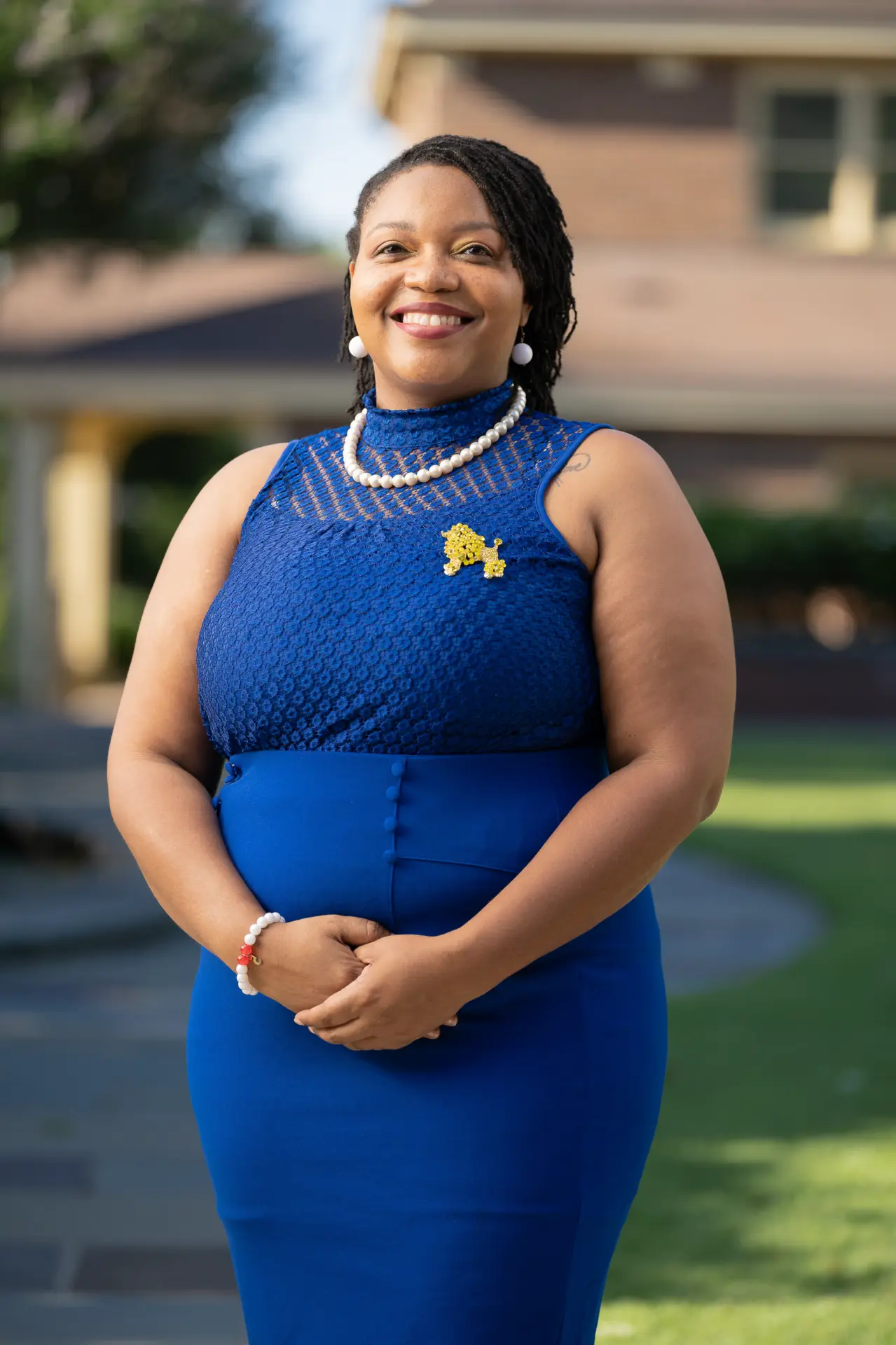 Woman in a royal blue dress smiling outdoors