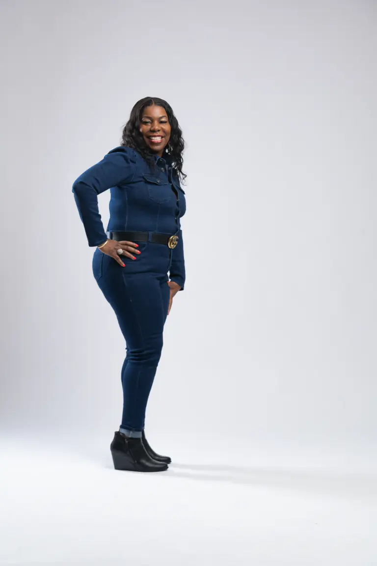 Woman smiling in a denim outfit during a studio portrait session