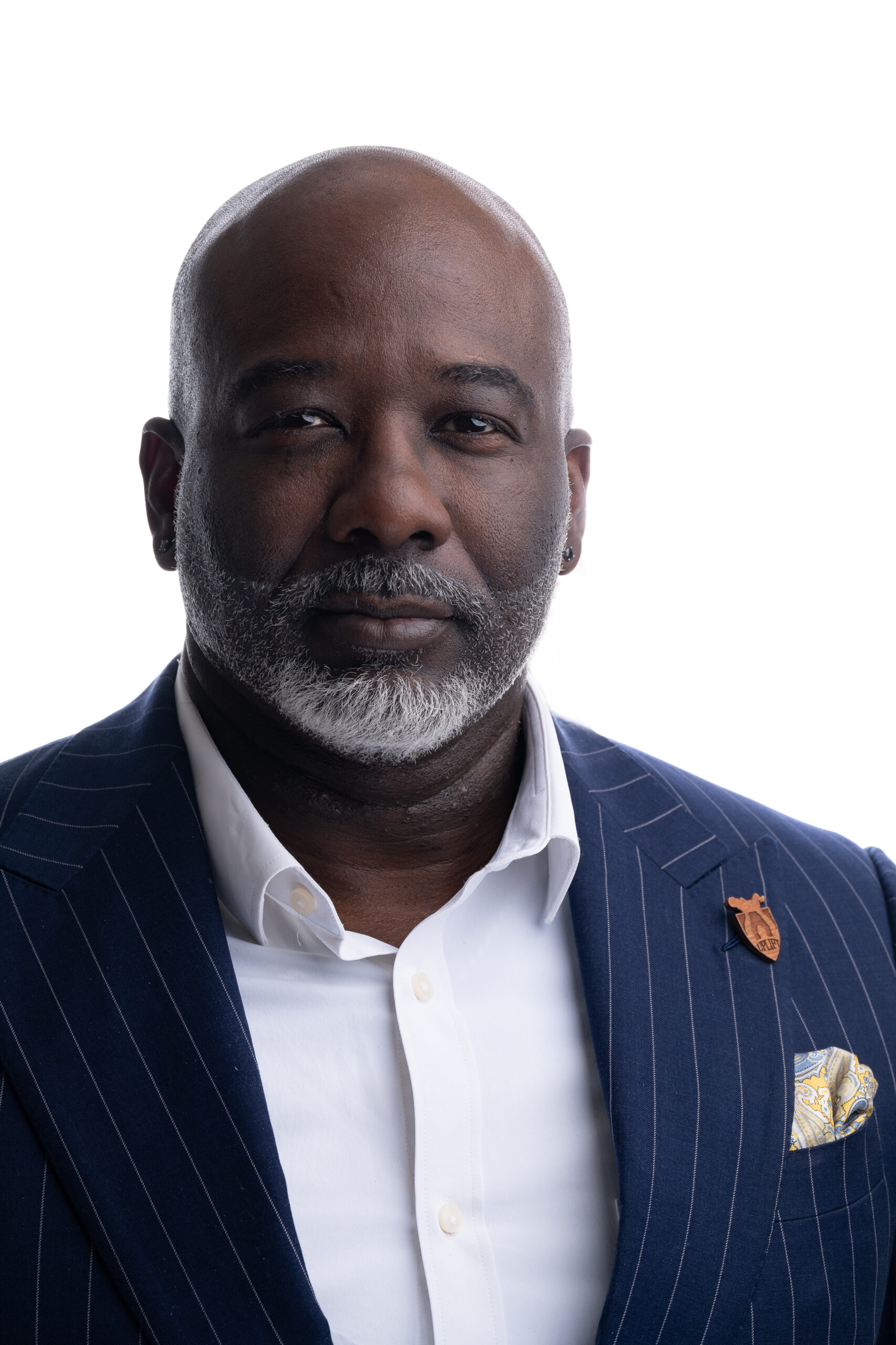 Professional headshot of a bearded man in a navy suit and tie
