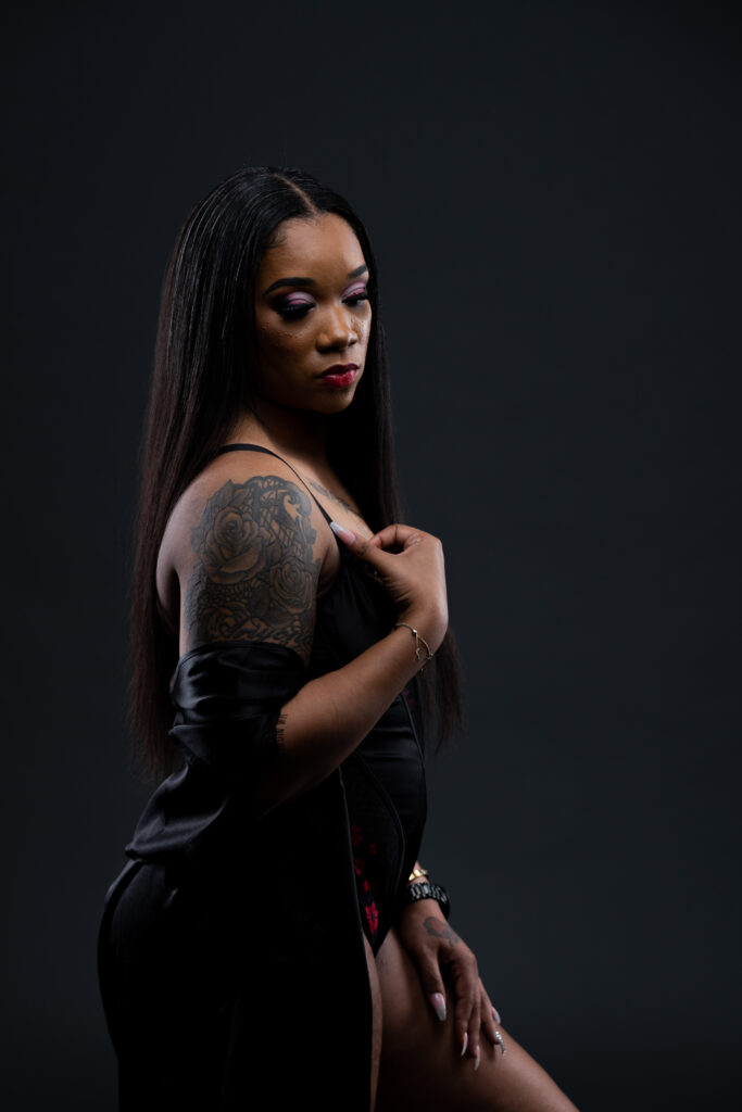 Woman in black posing in a moody studio portrait