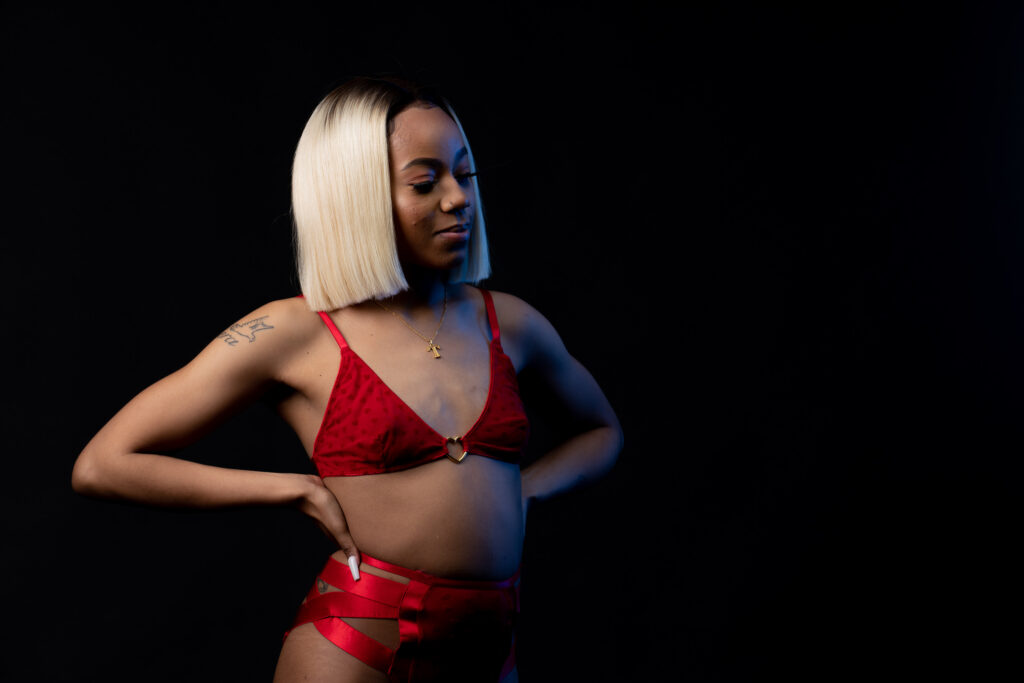 Woman with platinum hair in red against black, glamour portrait
