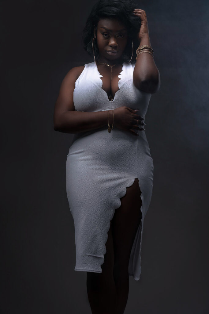 Woman in a gray bodycon dress, moody studio portrait