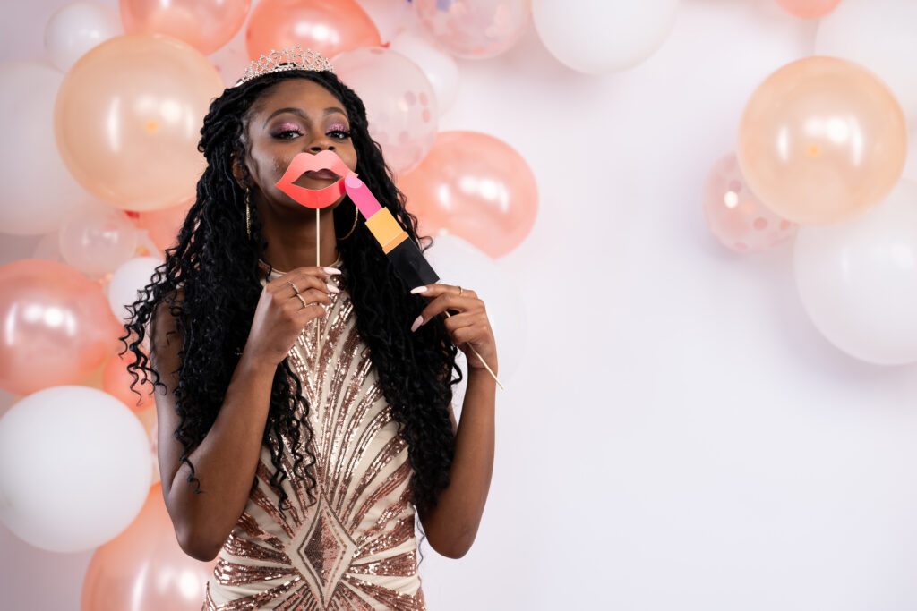 Woman with lips prop before a peach balloon garland