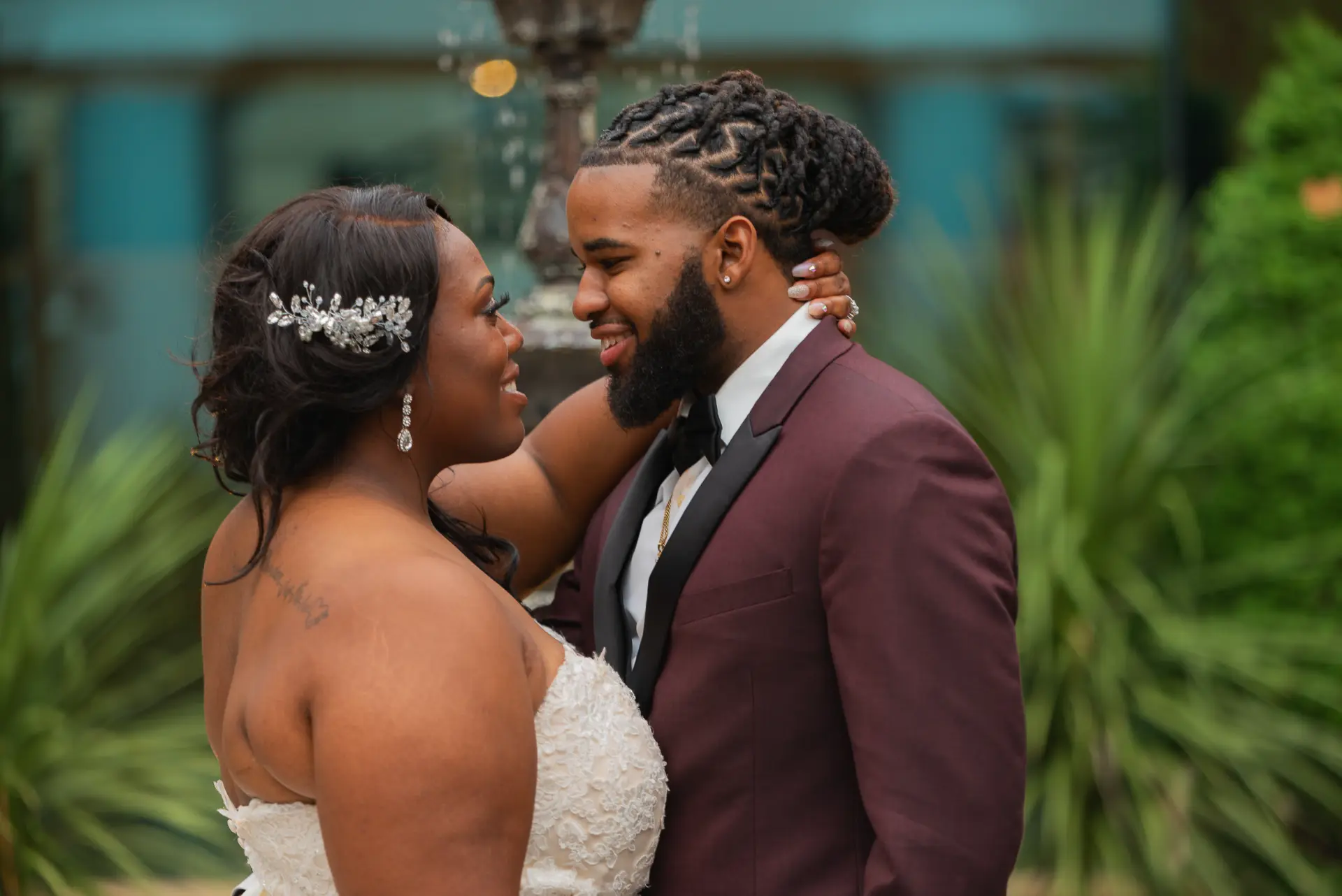 Bride and groom share a tender moment among tropical leaves