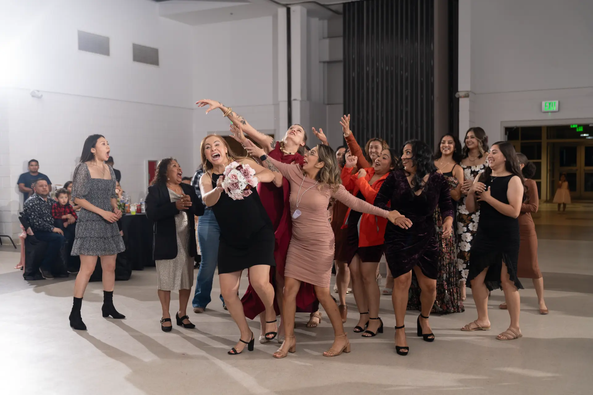 Guests fill the dance floor at a bright reception hall