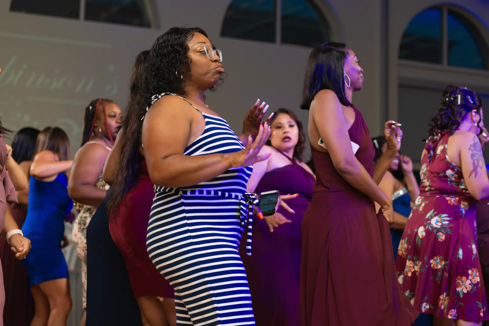 Guests in colorful outfits dance at the reception