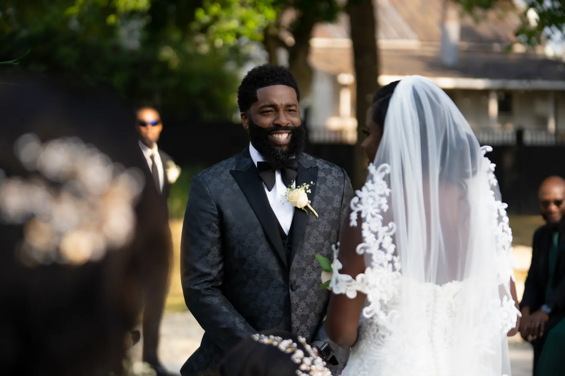 Groom smiles at the bride under her veil