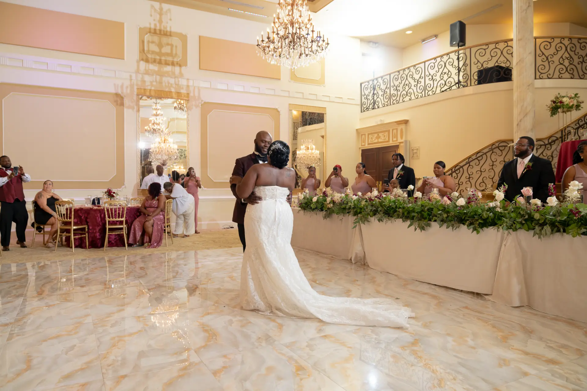 Bride walks across a grand ballroom with a long train
